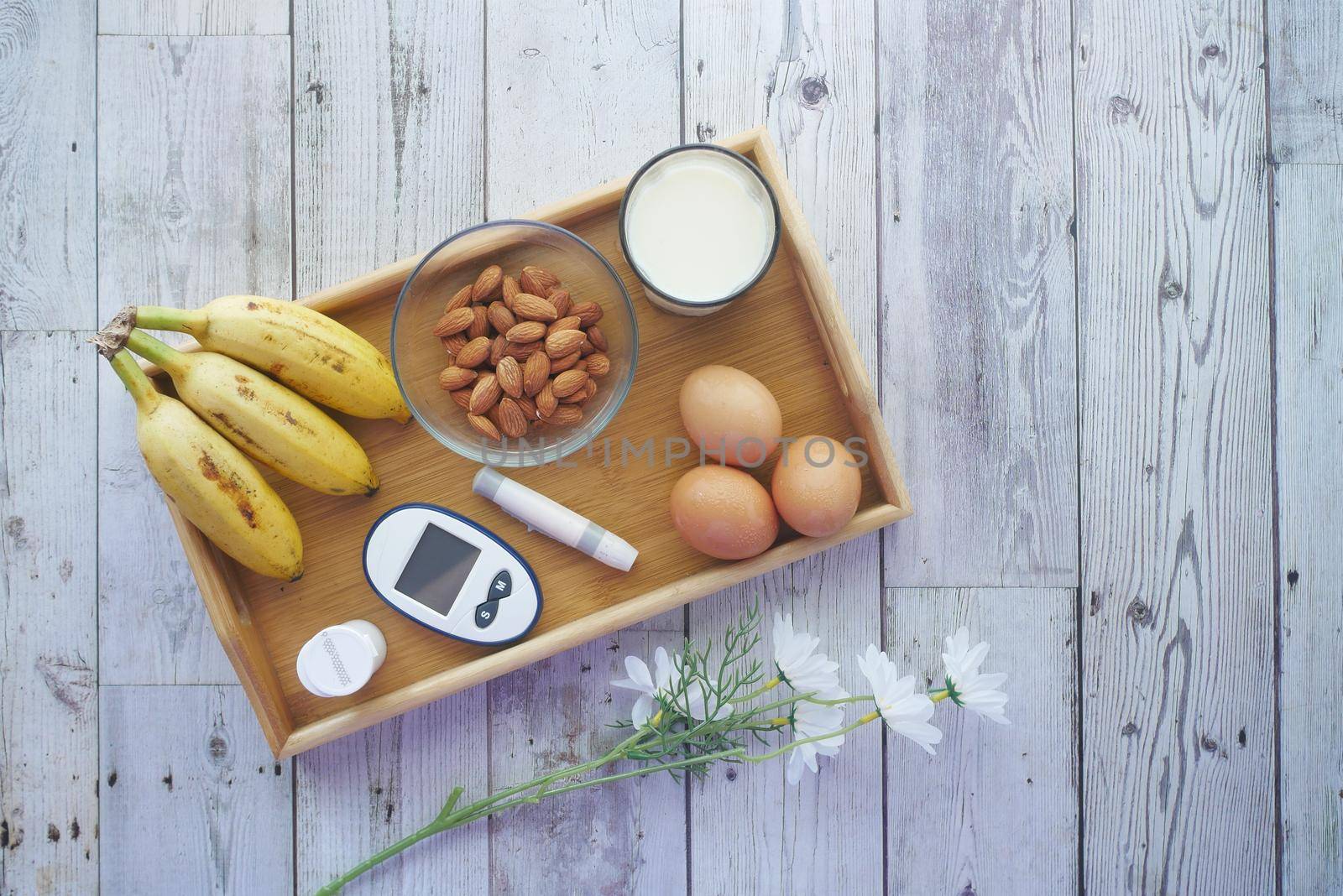 diabetic measurement tools, banana, eggs, milk on table .
