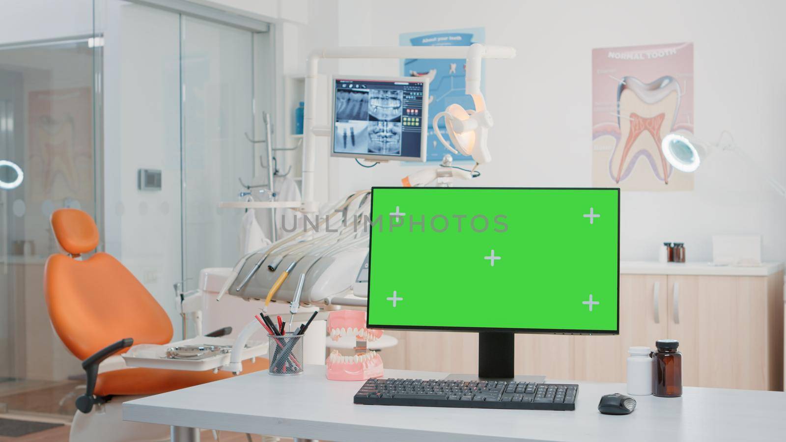 Nobody in stomatology office with green screen on computer for chroma key and mockup template. Dentist cabinet for oral and dental care with medical tools and isolated display on monitor