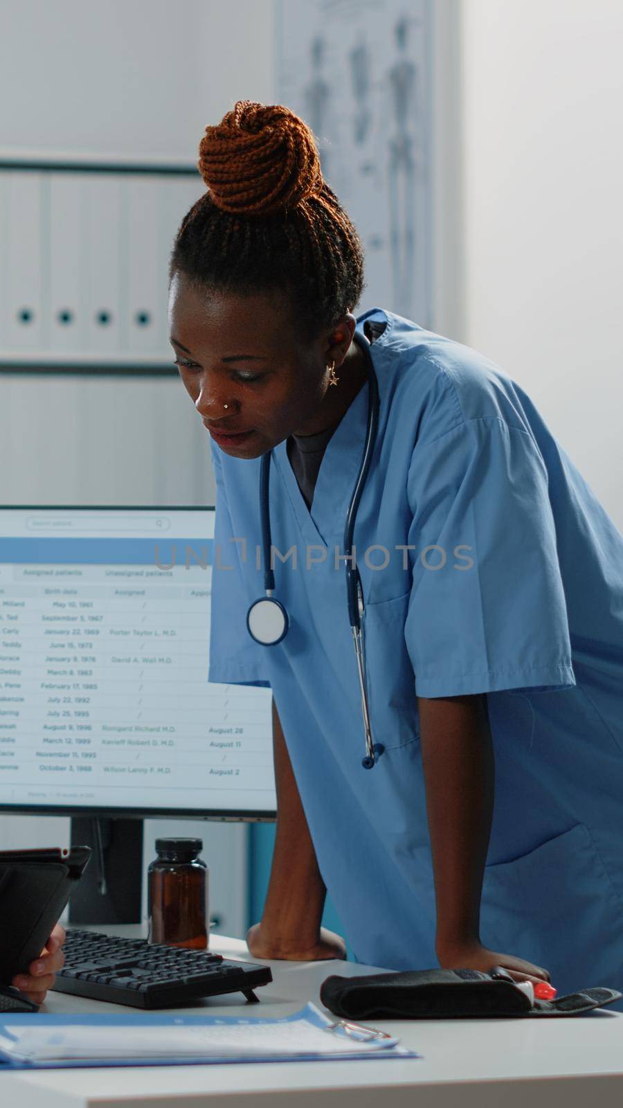 Multi ethnic team of nurses looking at digital tablet by DCStudio