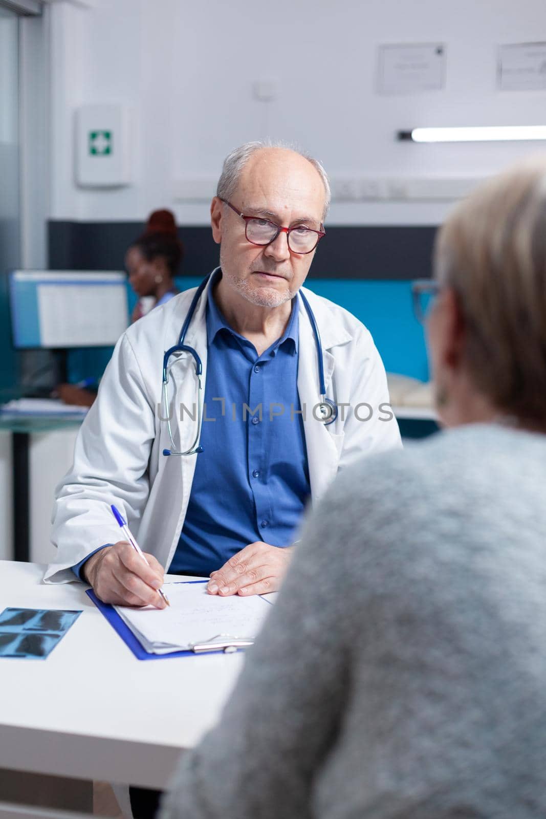 Medic signing checkup files to give prescription treatment to sick patient. Specialist writing diagnosis on clipboard papers, after doing medical consultation at checkup appointment.