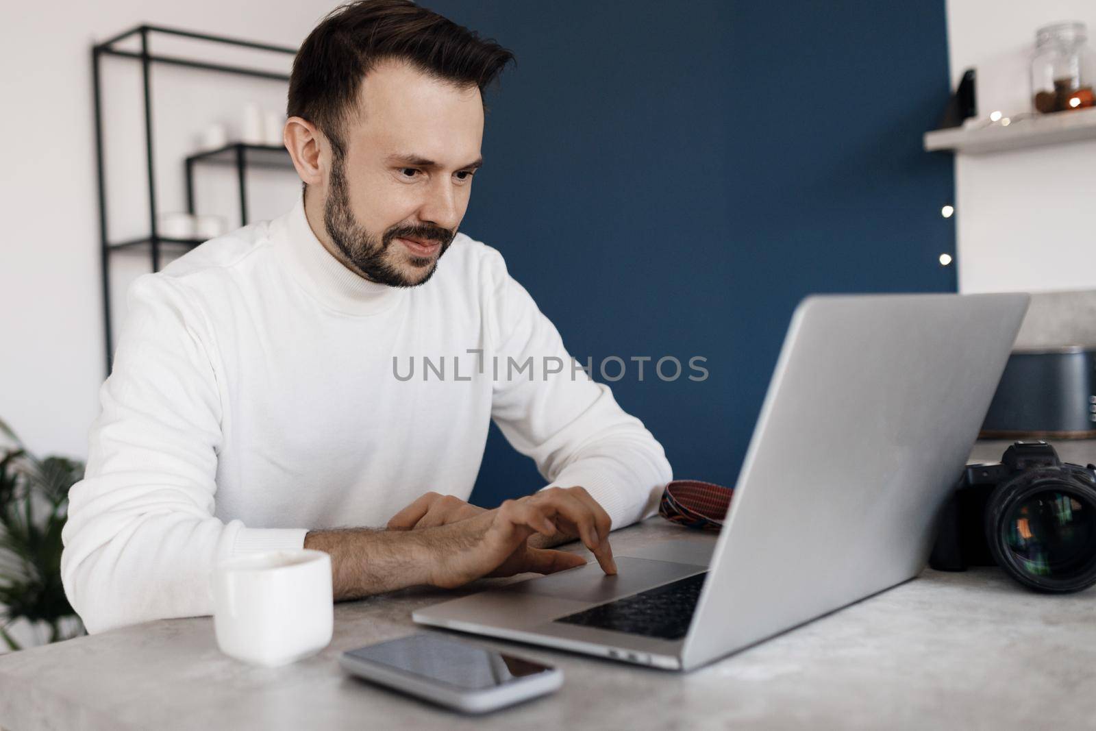 Handsome photographer with laptop and camera by splash