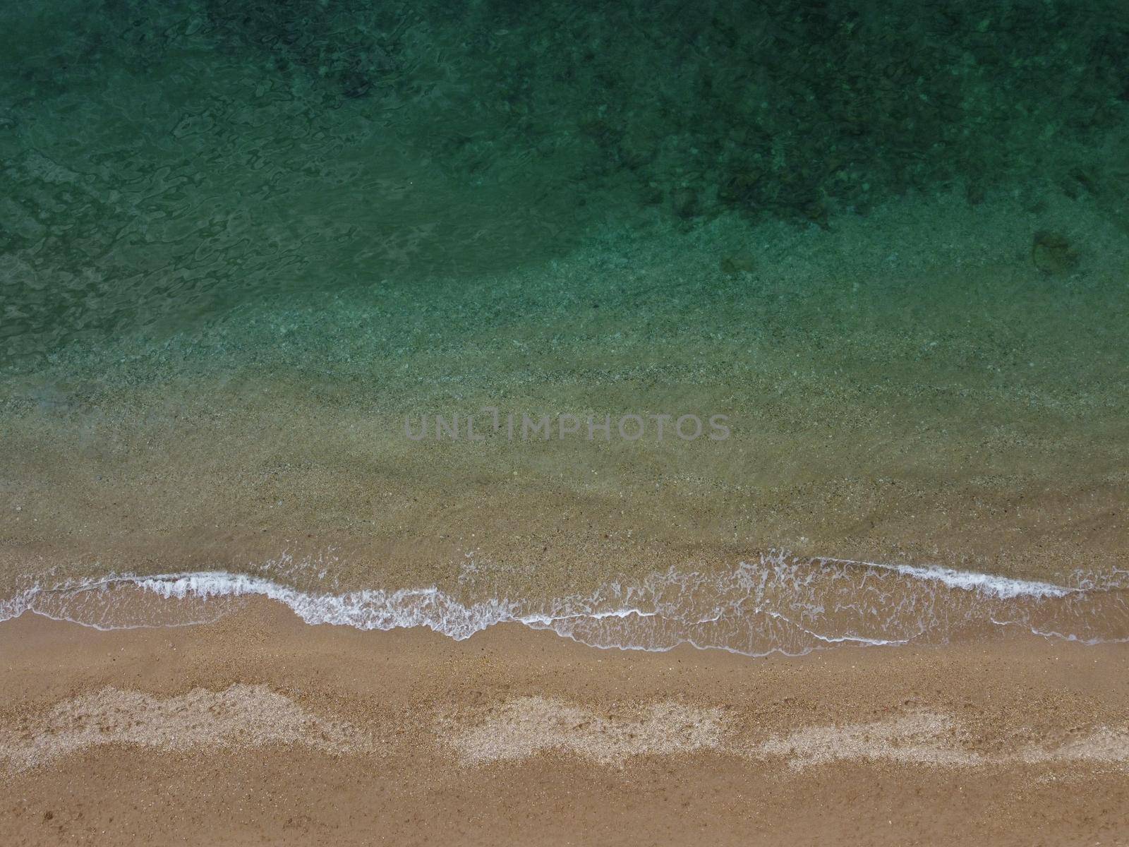 Beautiful remote beach with crystal clear azure water, aerial view. Untouched nature and hidden sandy beach with seagulls. Motion blur on small waves. Holiday, vacation and travel concept. Nobody by panophotograph