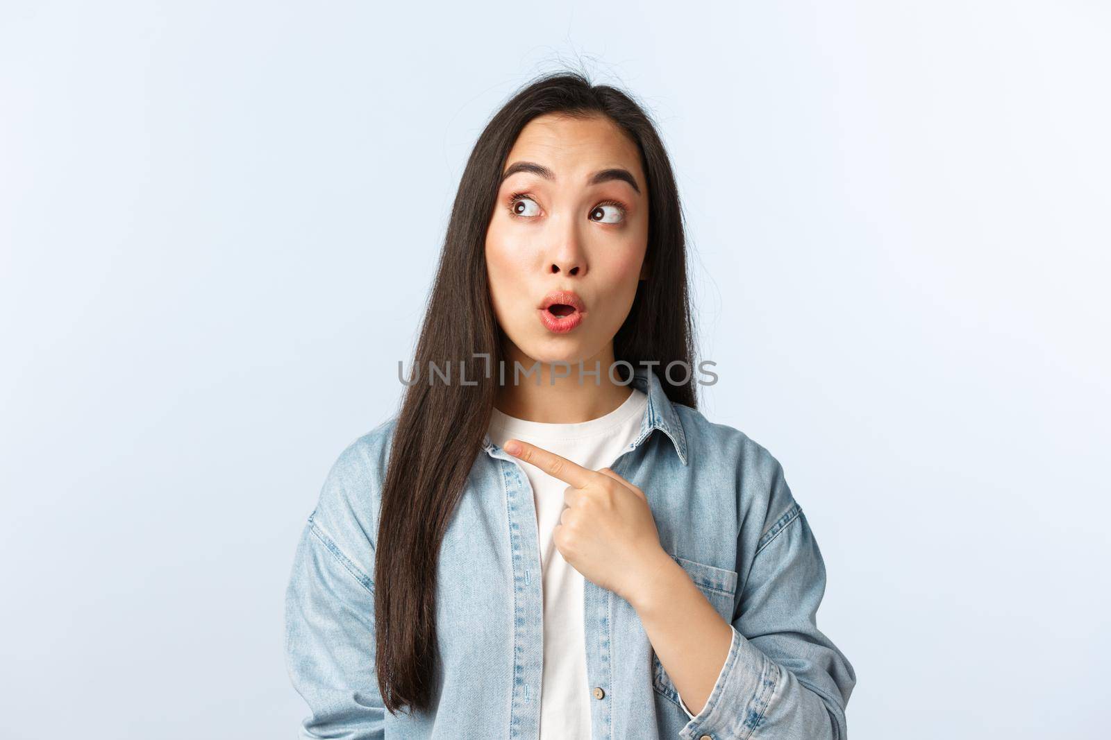 Lifestyle, people emotions and beauty concept. Excited intrigued asian girl in casual outfit, say wow as staring and pointing top left advertisement, showing awesome promotion by Benzoix