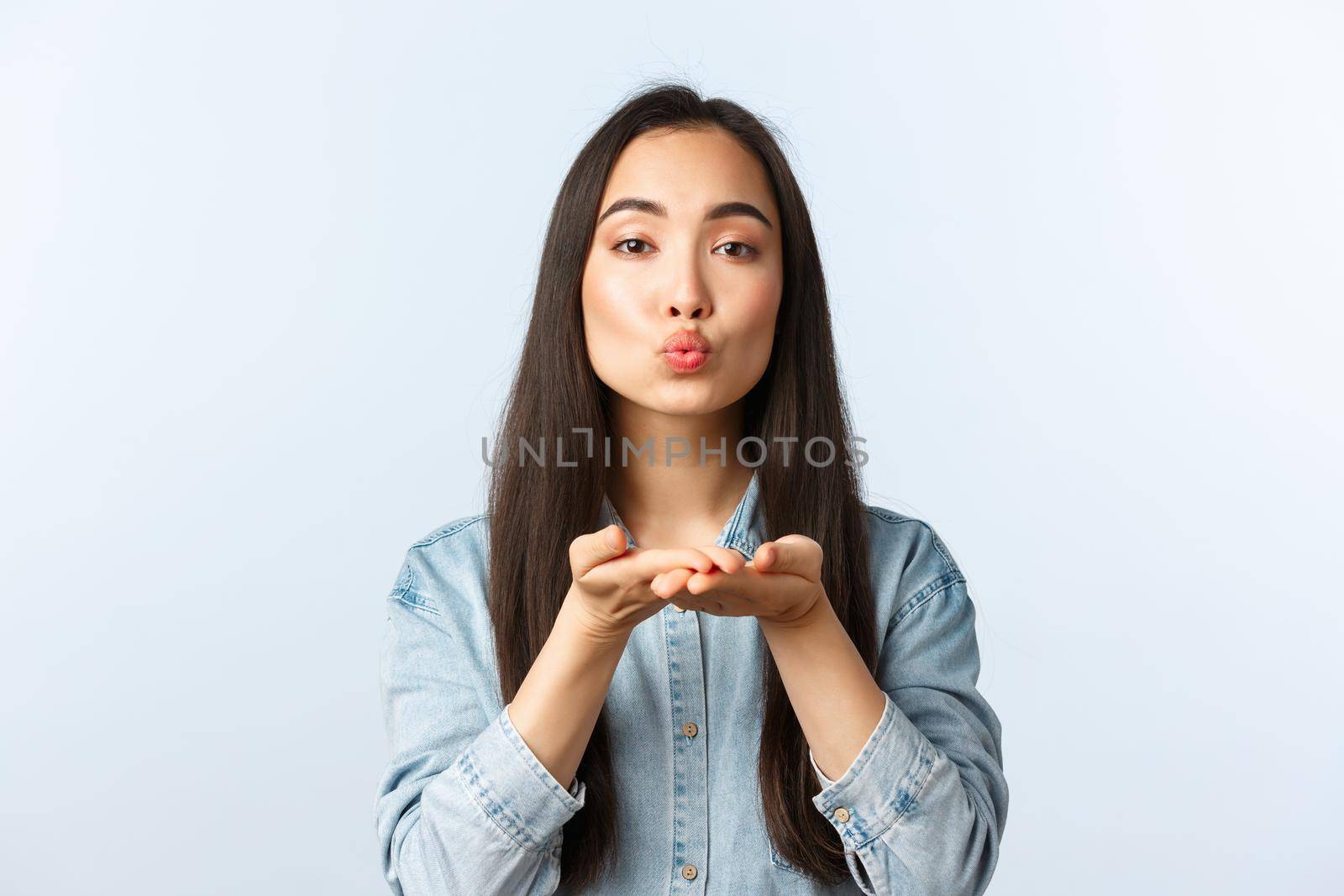 Lifestyle, people emotions and beauty concept. Romantic cute and silly korean girl fold lips and blowing air kiss at camera with caring and dreamy expression, show sympathy and love by Benzoix