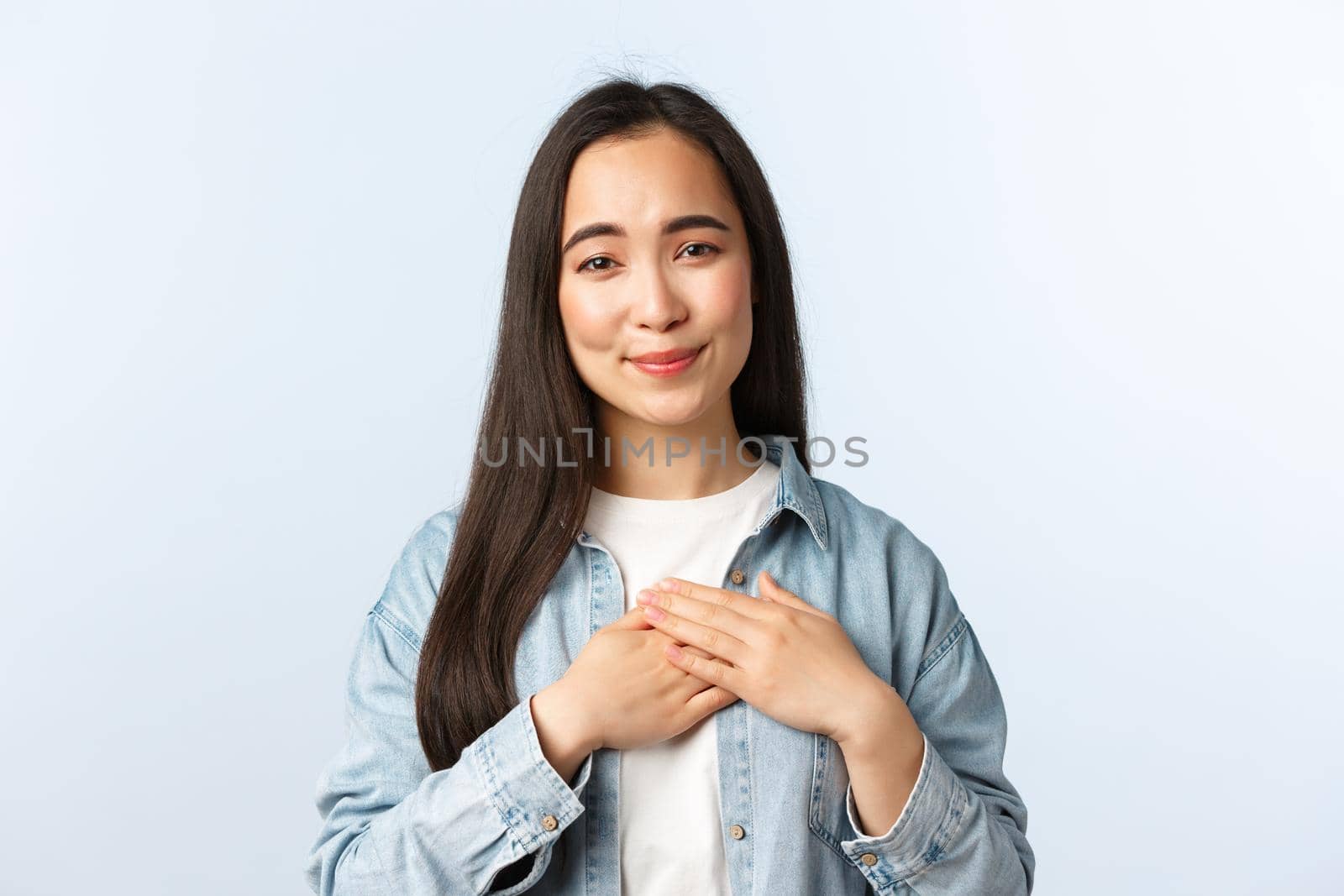 Lifestyle, people emotions and beauty concept. Lovely korean girl in casual outfit, touching heart and smiling pleased, feeling thankful or grateful for compliments, being praised.