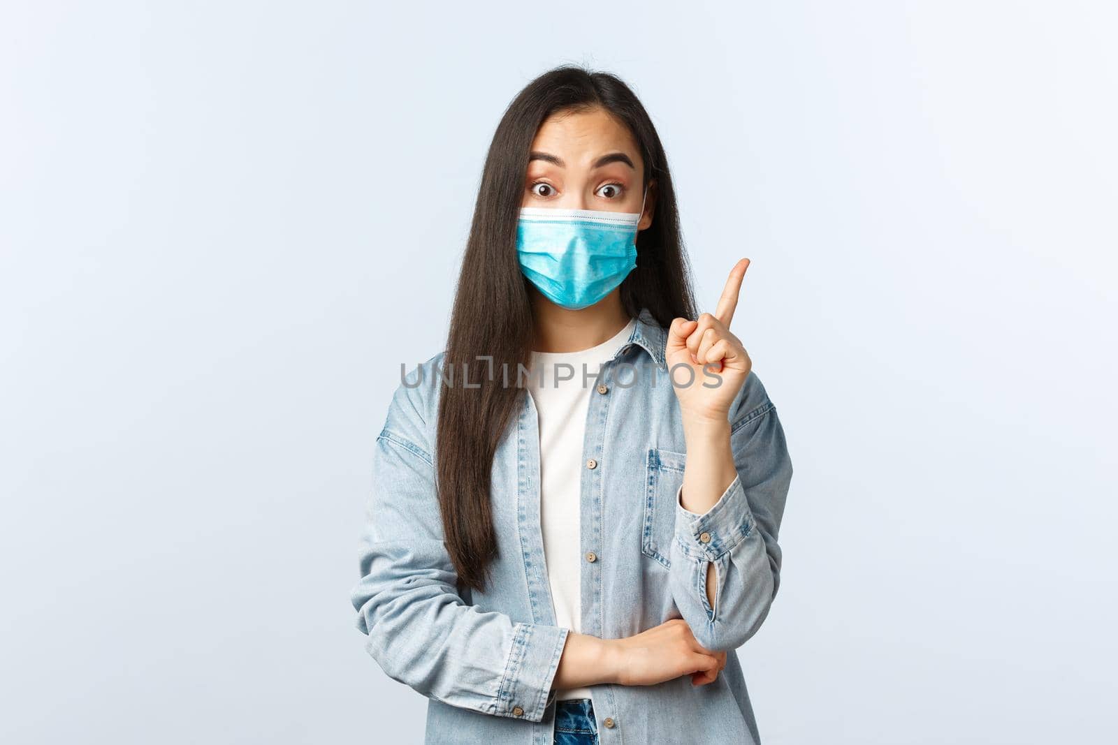 Social distancing lifestyle, covid-19 pandemic everyday life and leisure concept. Creative asian girl got an idea, wear medical mask and gasping as have plan, raise index finger eureka gesture by Benzoix