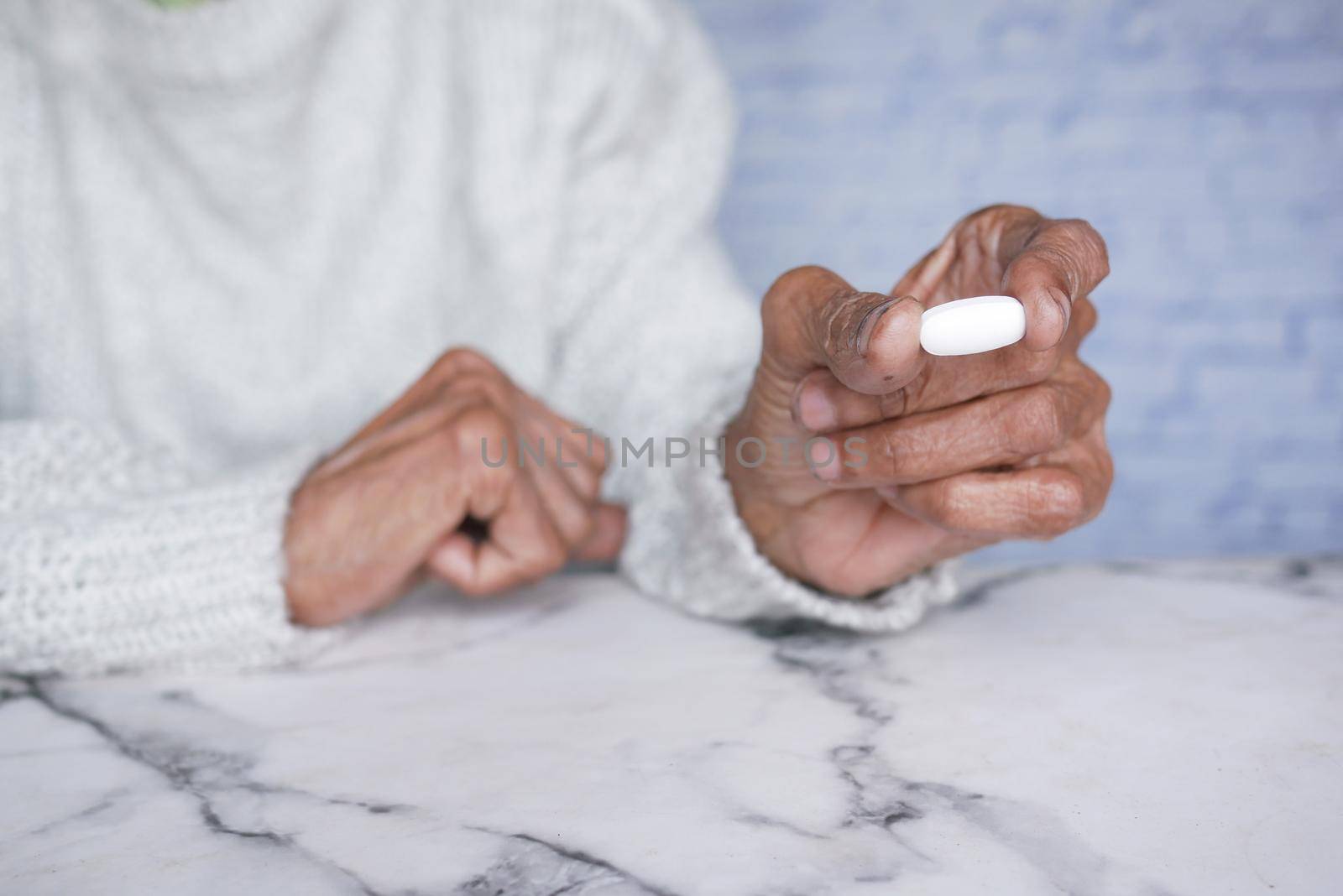 senior women holding a medical pills while sited .
