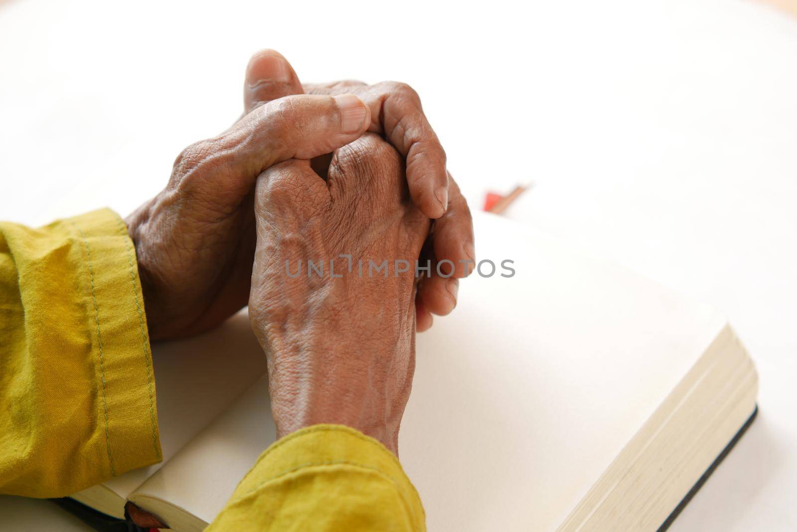 person holding a bible in his hands and praying