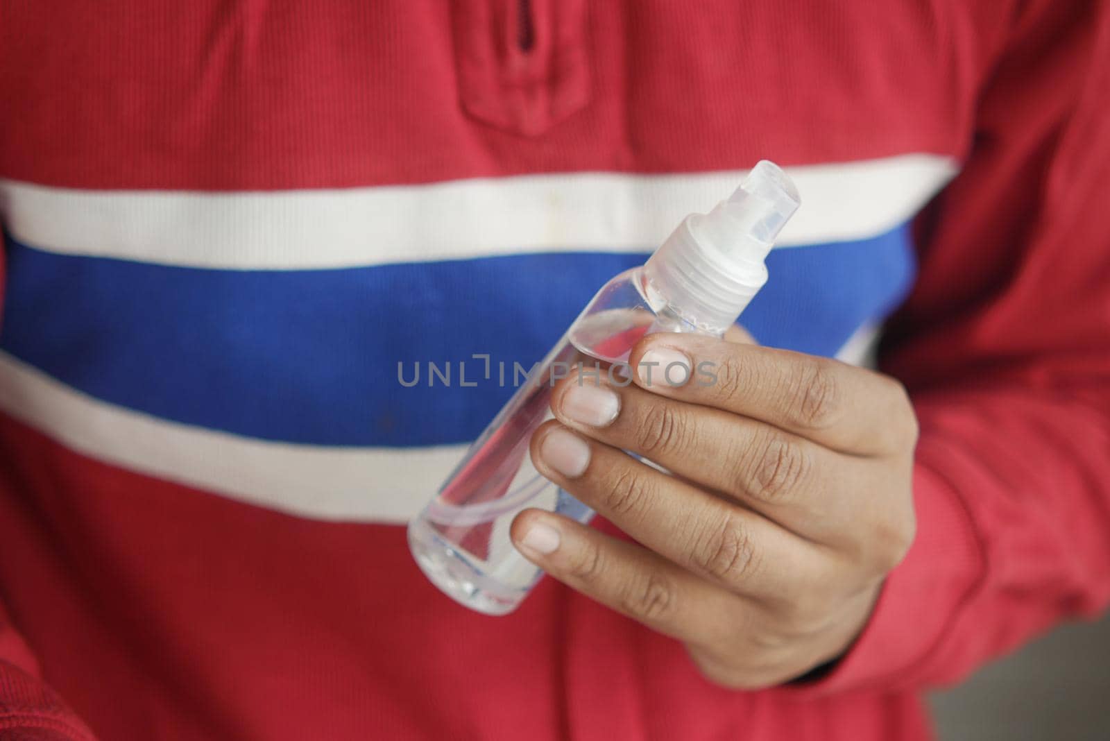 close up of young man hand using hand sanitizer spray