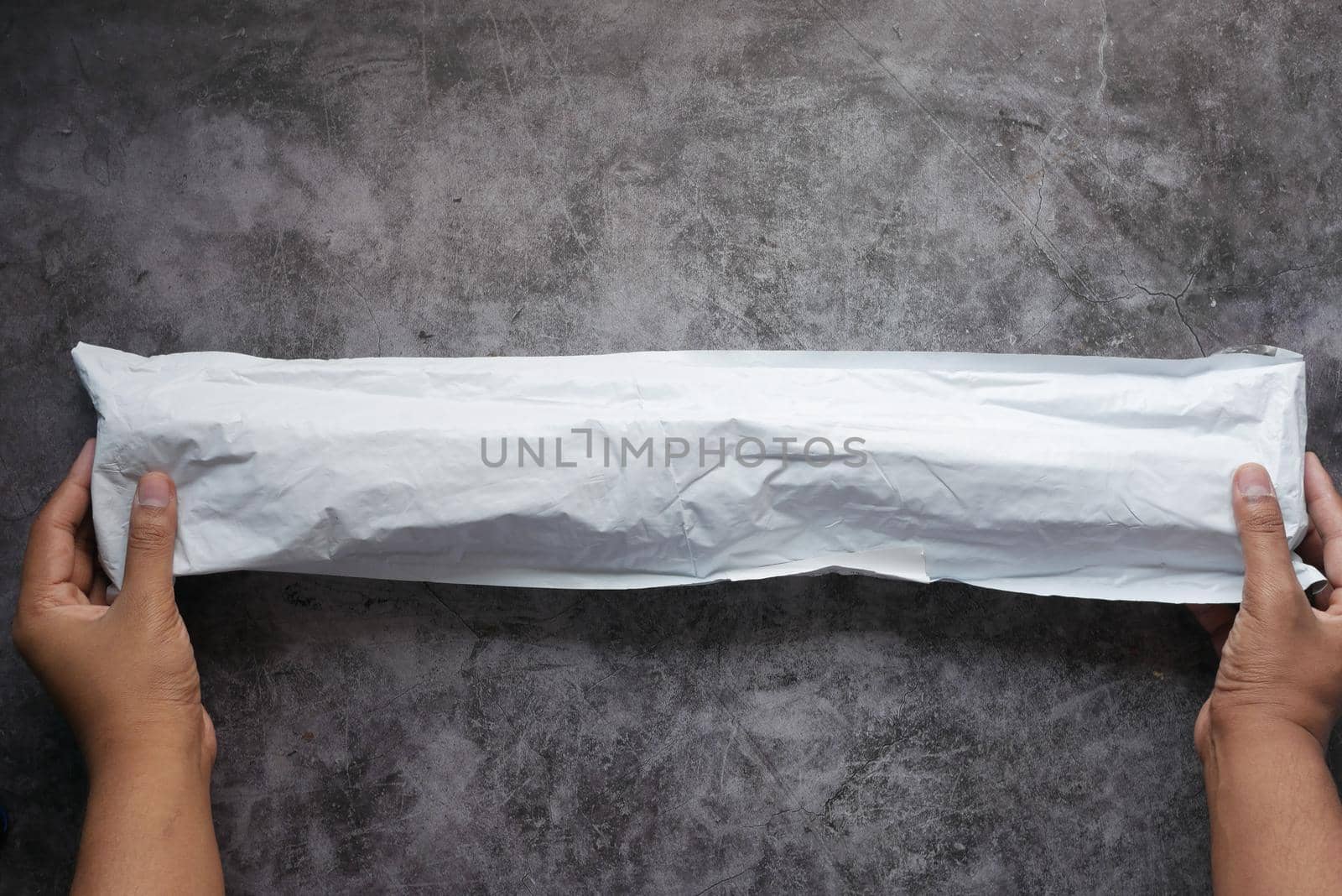 holding a delivery envelope on black background .