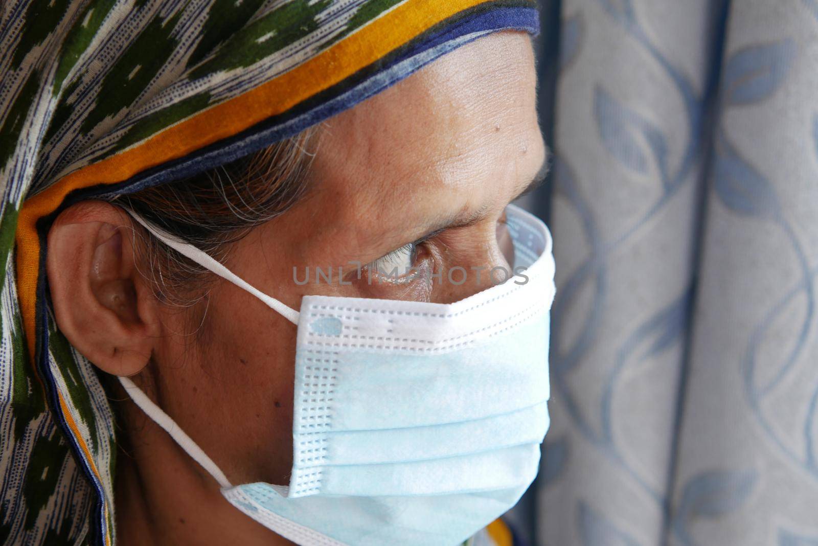 portrait of an old woman wearing a surgical mask,