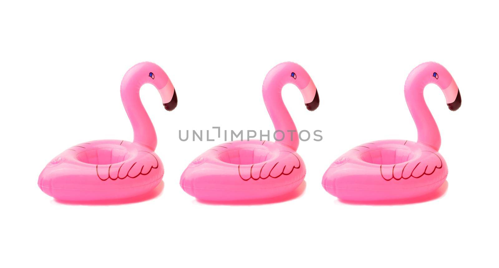 three inflatable small flamingos on an isolated white background. Coasters for the pool. The concept of summer pastime. Beach summer composition by Alla_Morozova93