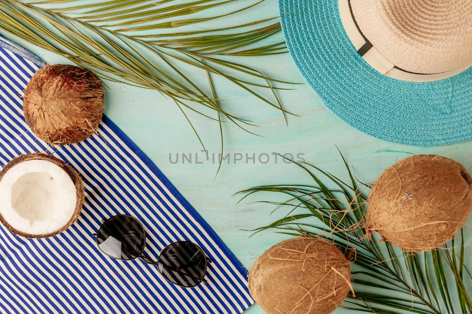 Summer composition or layout. Tropical palm leaves, hat, glasses, beach towel, coconut on a background of sea greens. The concept of the summer season and heat. Flat lay, top view, copy space by Alla_Morozova93