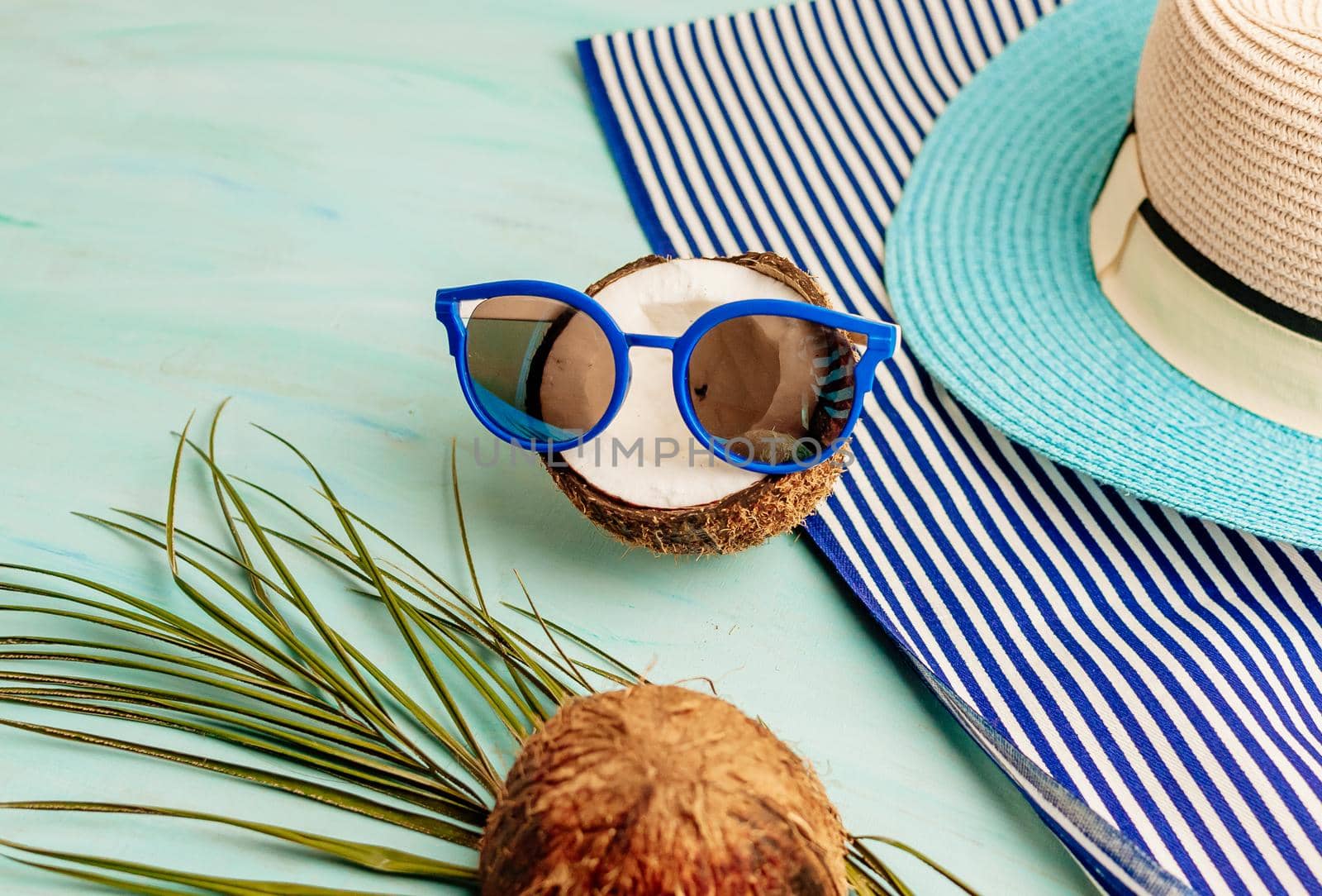 Summer composition or layout. Tropical palm leaves, hat, glasses, beach towel, coconut on a background of sea greens. The concept of the summer season and heat. Flat lay, top view, copy space by Alla_Morozova93