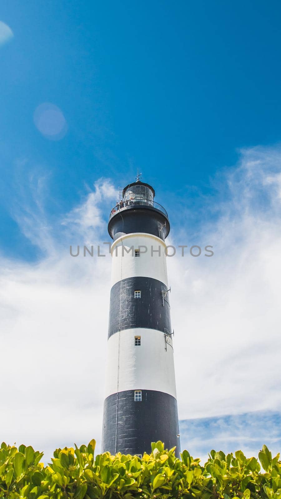 The Chassiron lighthouse with black and white stripes on blue sky, on the island of Oléron in France