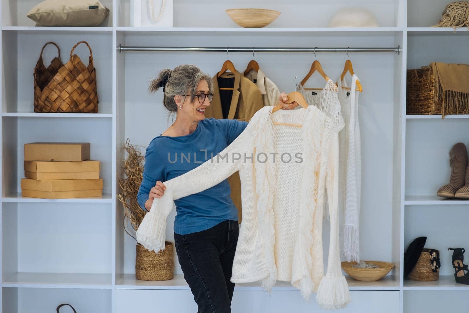 Elderly woman during chooses white sweater