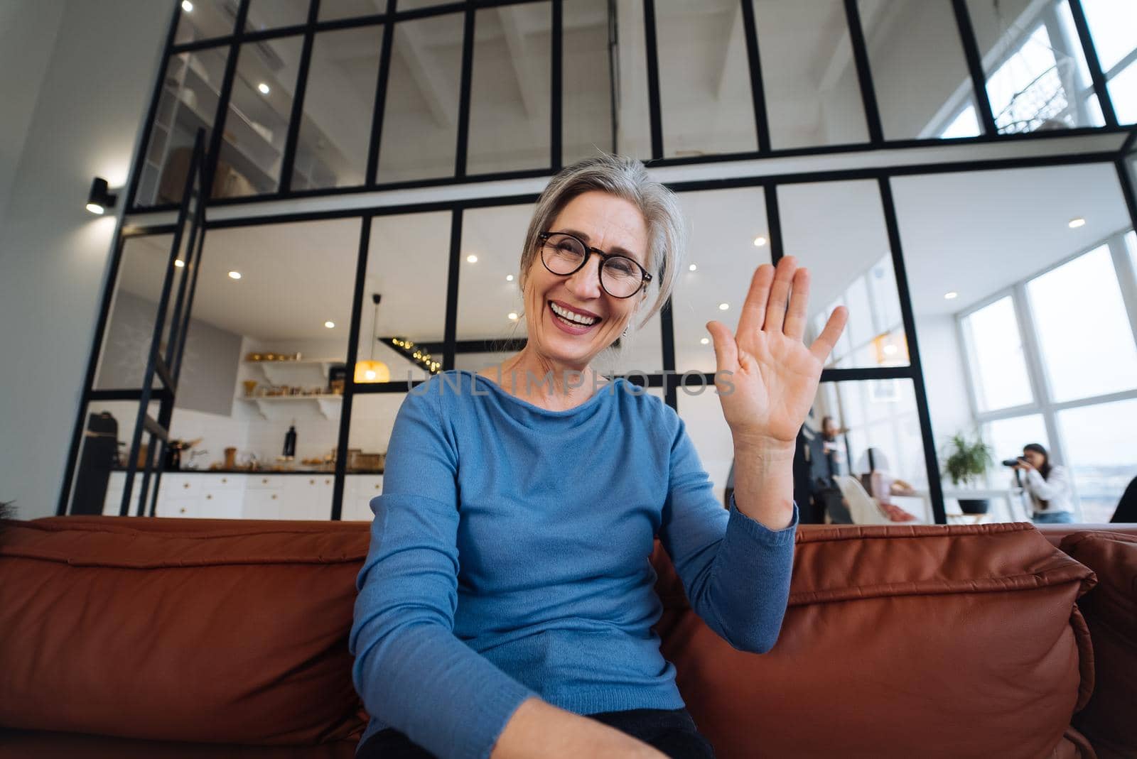 Middle Aged Woman Smiles and Waves to the Camera