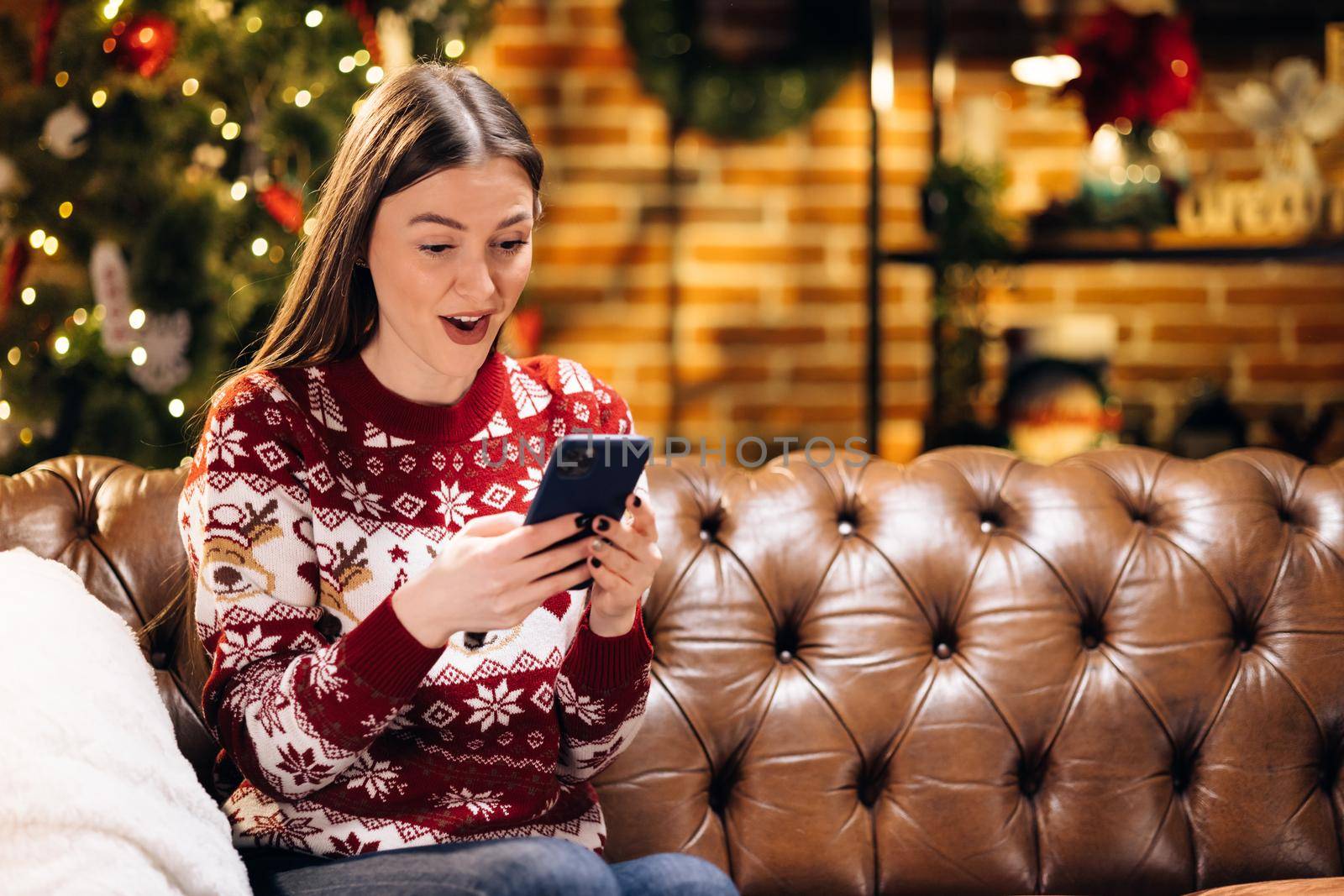 Happy laughing amazed caucasian woman looking at smartphone screen, getting message with unbelievable news, celebrating winning New Year or Christmas online lottery. Internet success concept.