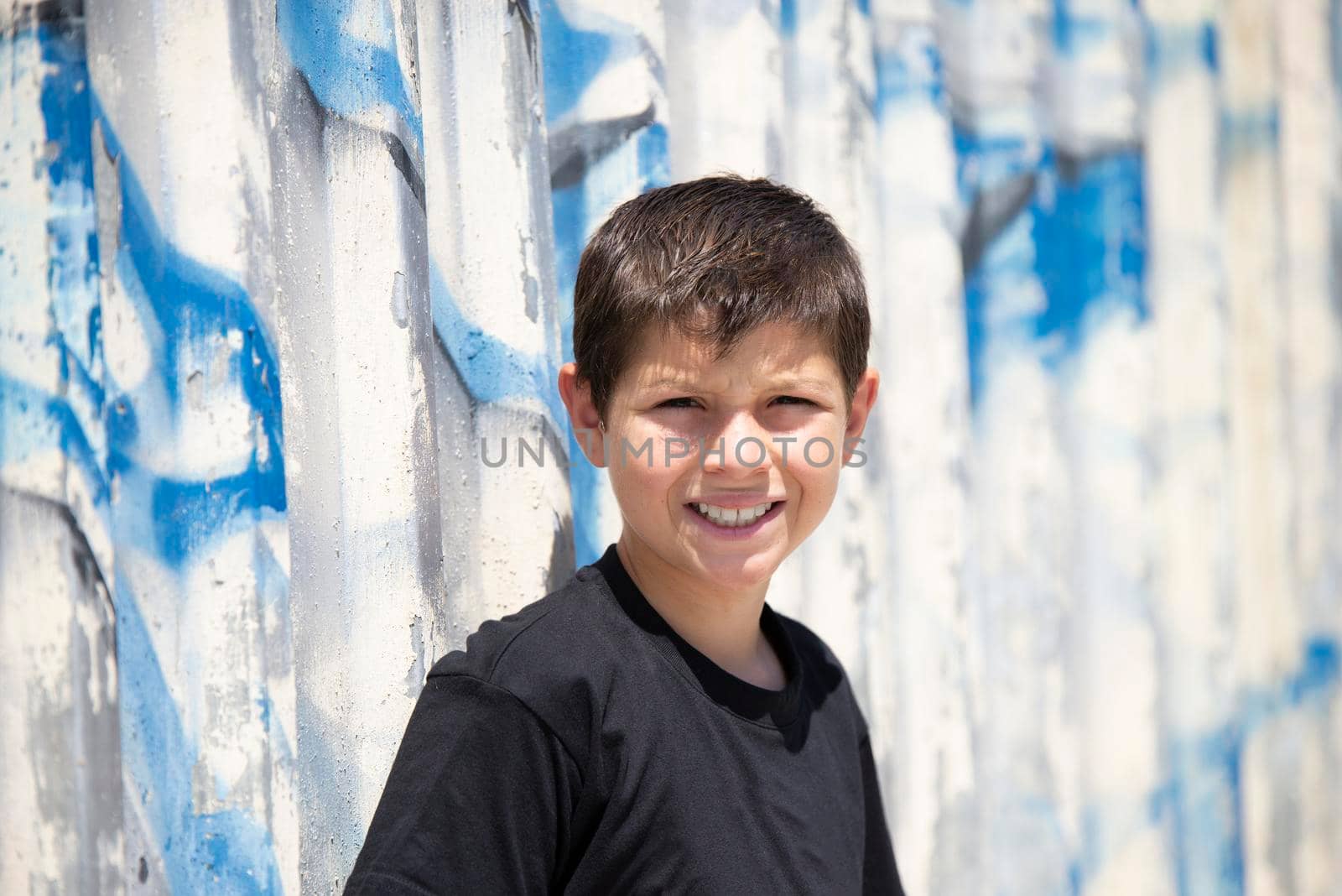 Portrait of handsome male child in the city outdoors. Natural light.