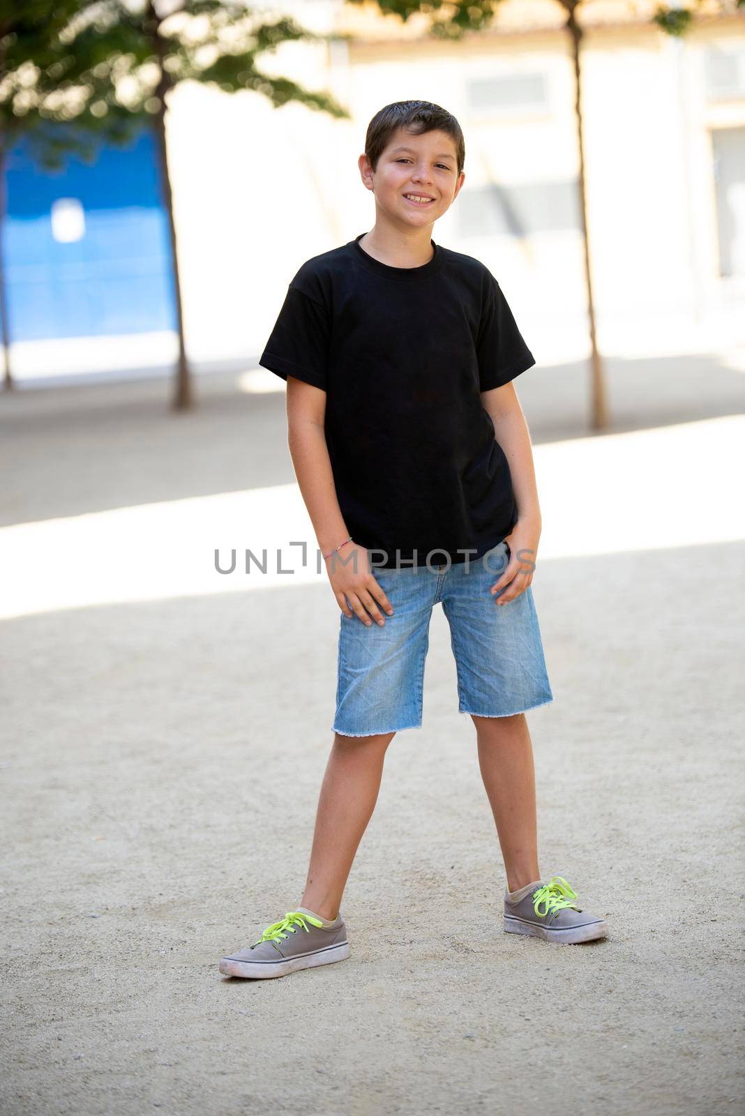 Portrait of handsome male child in the city outdoors. Natural light.