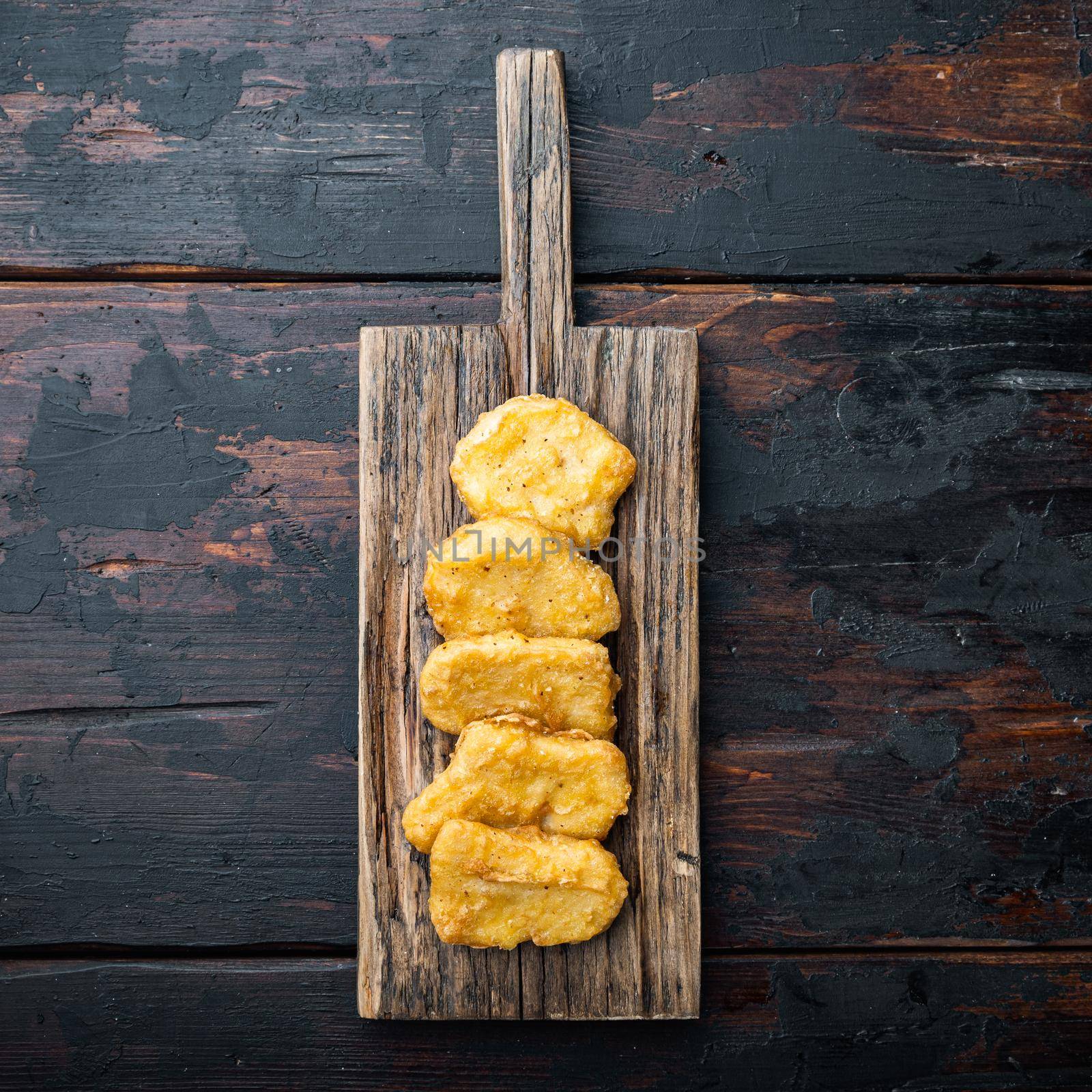 Chicken nuggets fried on dark wooden background, with space for text.