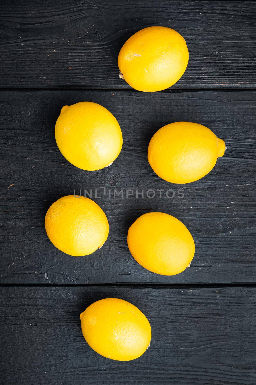 Fresh lemons, on black wooden table background, top view flat lay by Ilianesolenyi