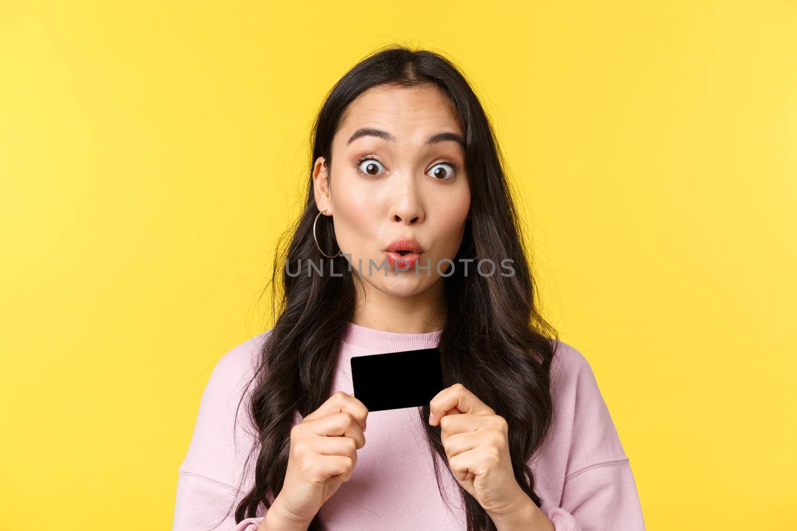 People emotions, lifestyle leisure and beauty concept. Amused excited asian girl holding credit card, gazing camera as ready buy everything in store, going shopping for summer vacation.