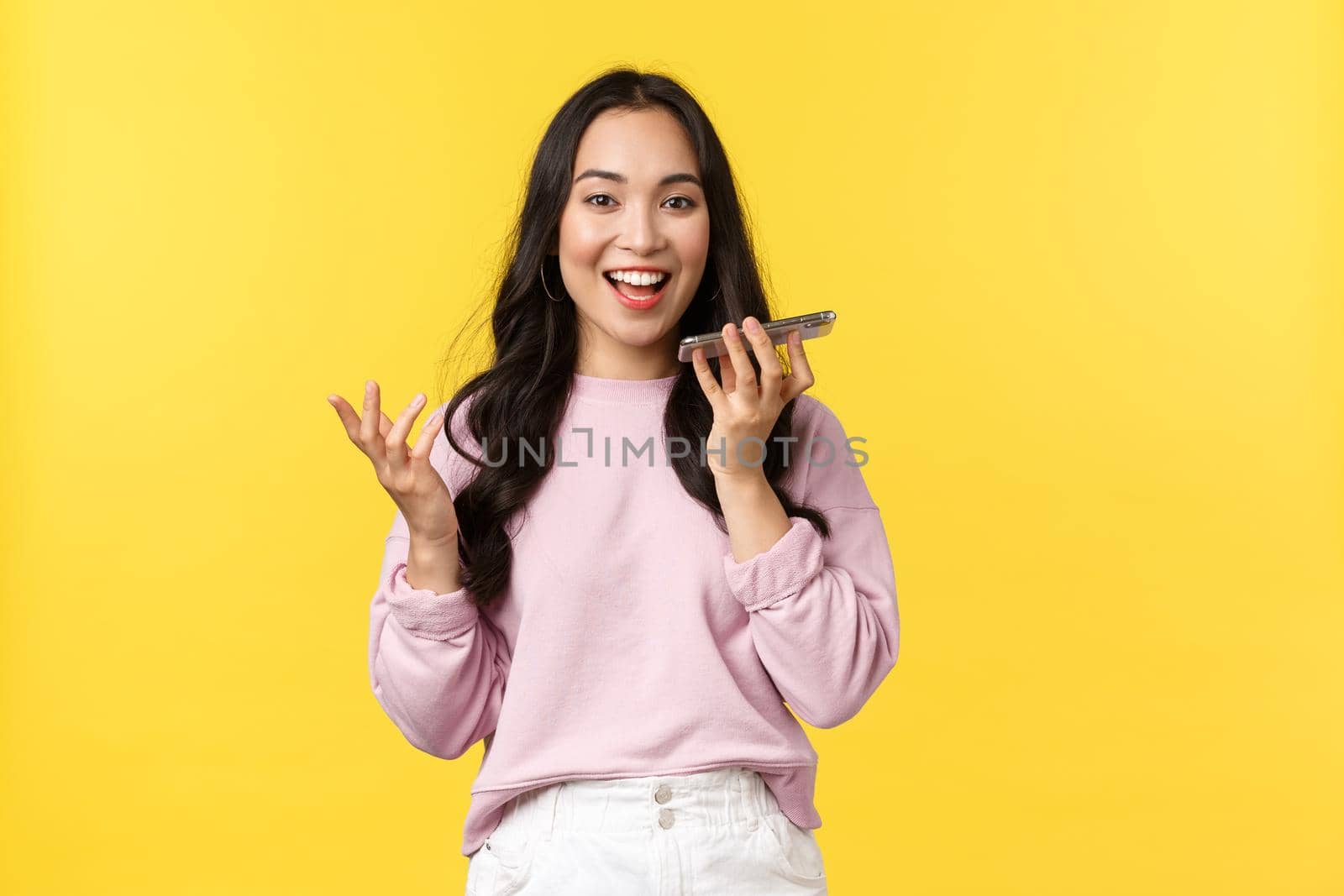 People emotions, lifestyle leisure and beauty concept. Thoughtful cute asian girl record voice-message in mobile application, gesturing and holding smartphone speaker near mouth by Benzoix