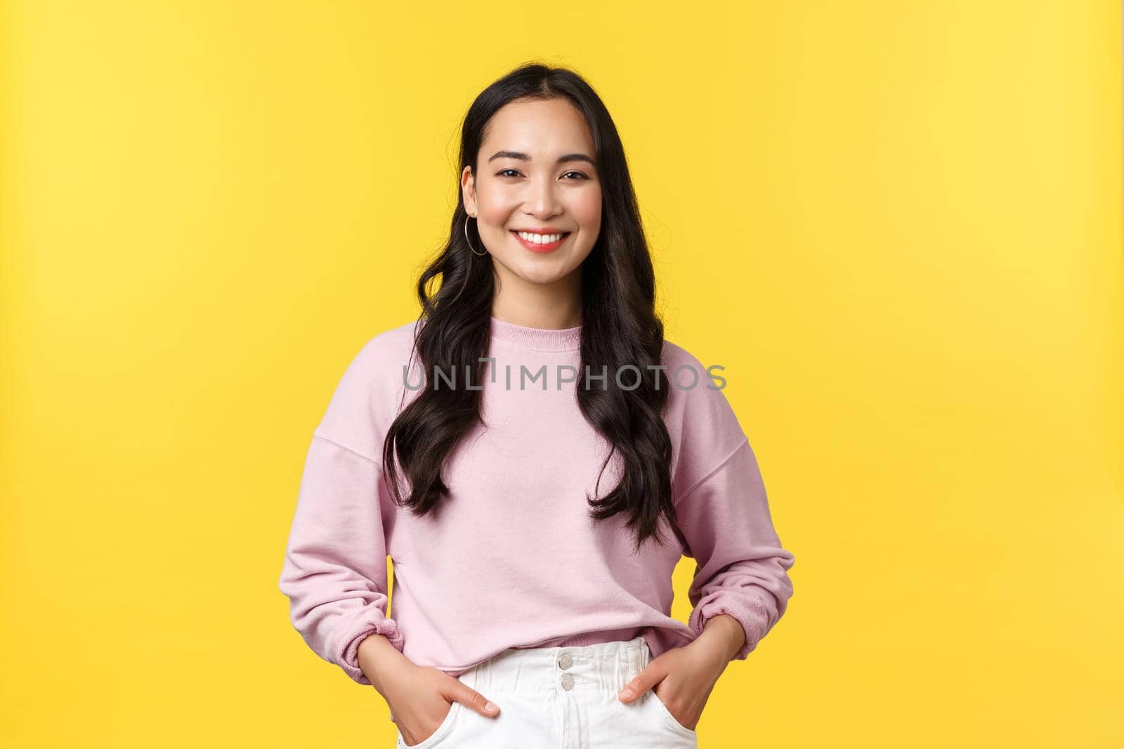 People emotions, lifestyle and fashion concept. Smiling cute asian girl in stylish clothes smiling camera, standing yellow background with happy expression, enjoying summer.