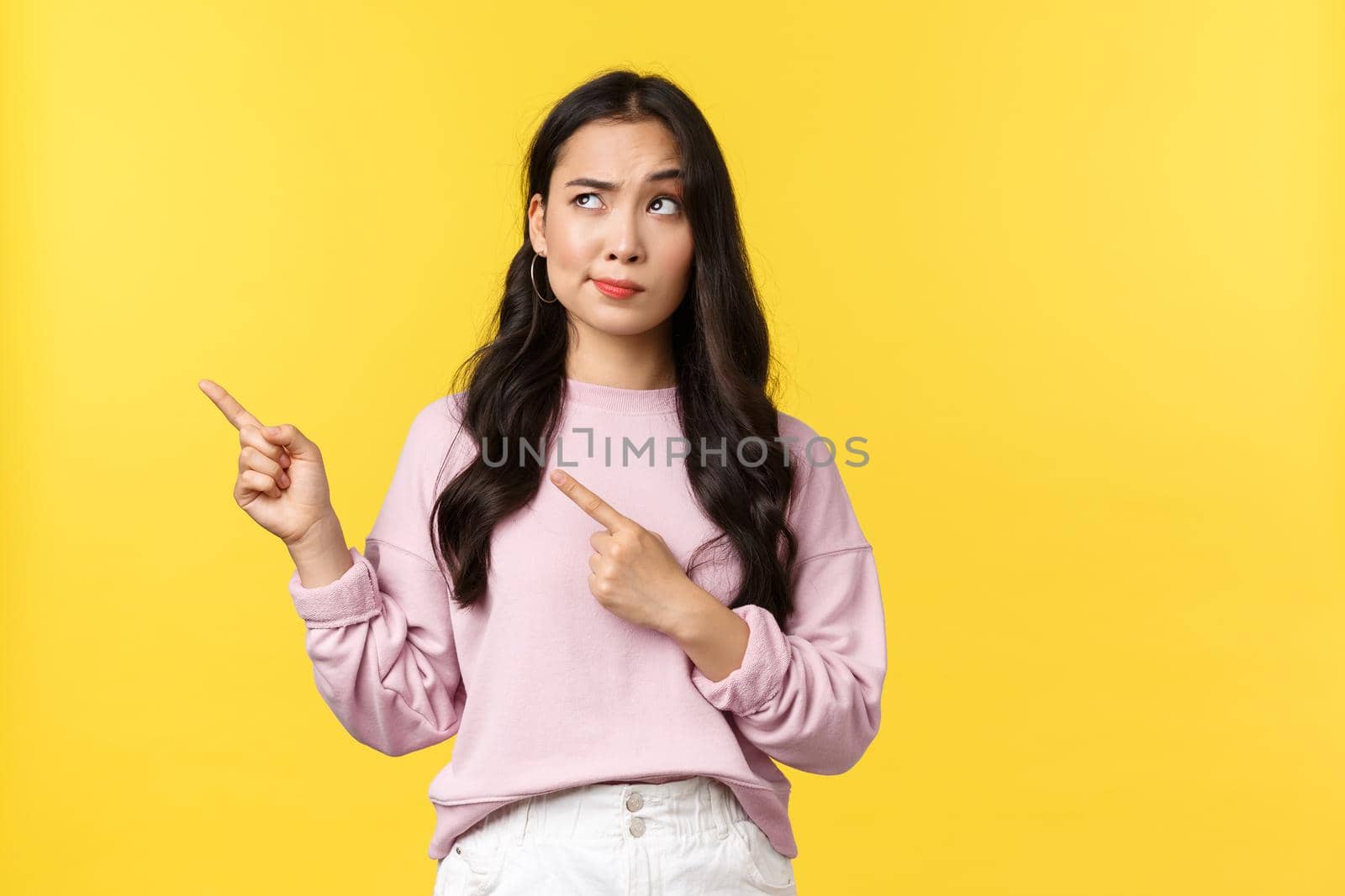People emotions, lifestyle and fashion concept. Skeptical and doubtful modern asian woman in stylish outfit smirk disbelief and dislike as pointing upper left corner at bad advertisement by Benzoix