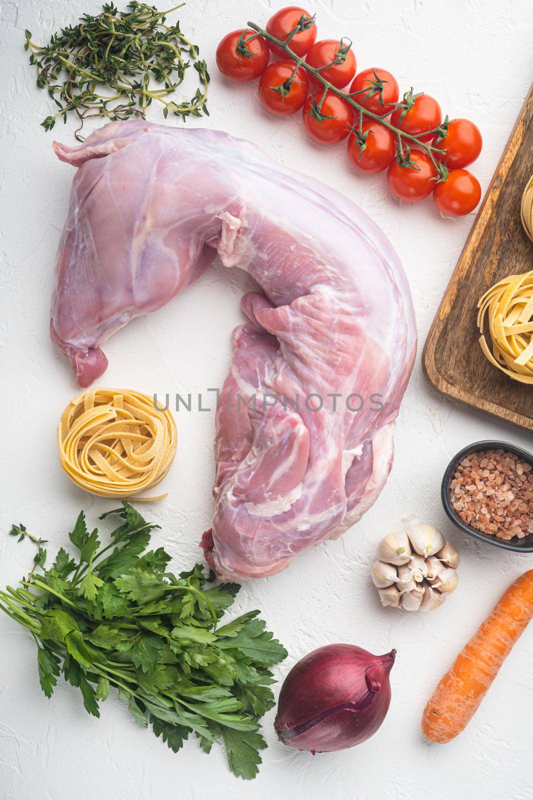 Whole rabbit, Raw meat with spices and vegetables, ingredients for stewing set, on white stone background, top view flat lay