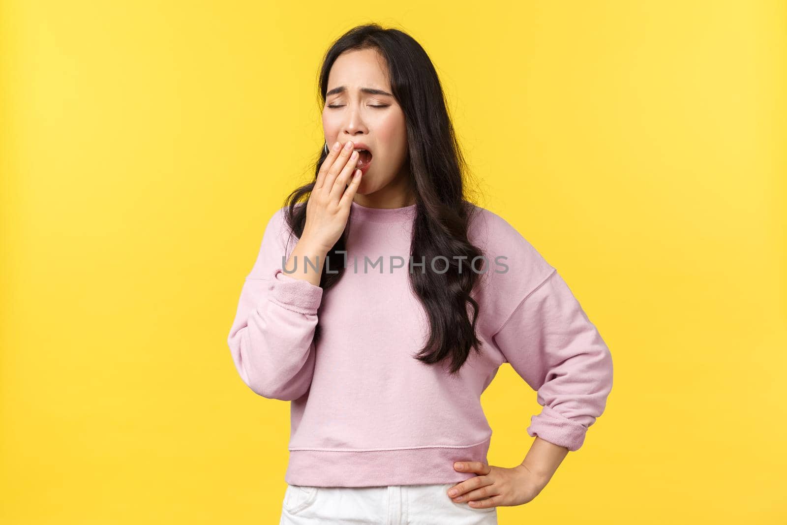 Lifestyle, emotions and advertisement concept. Tired asian female employee wants sleep, feeling exhausted after long nish, yawning, covering opened mouth with hand, wake-up early.