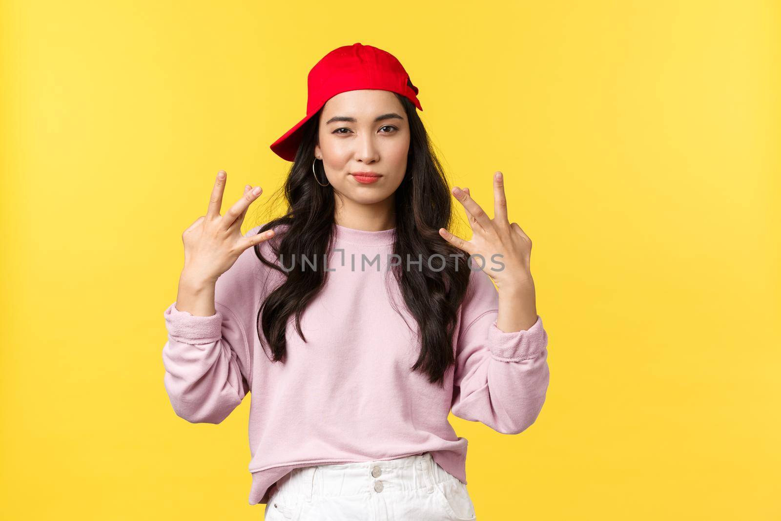 People emotions, lifestyle leisure and beauty concept. Stylish and cute hip-hop dancer girl, showing swag gesture and smirk sassy, acting confident and cool, standing yellow background by Benzoix