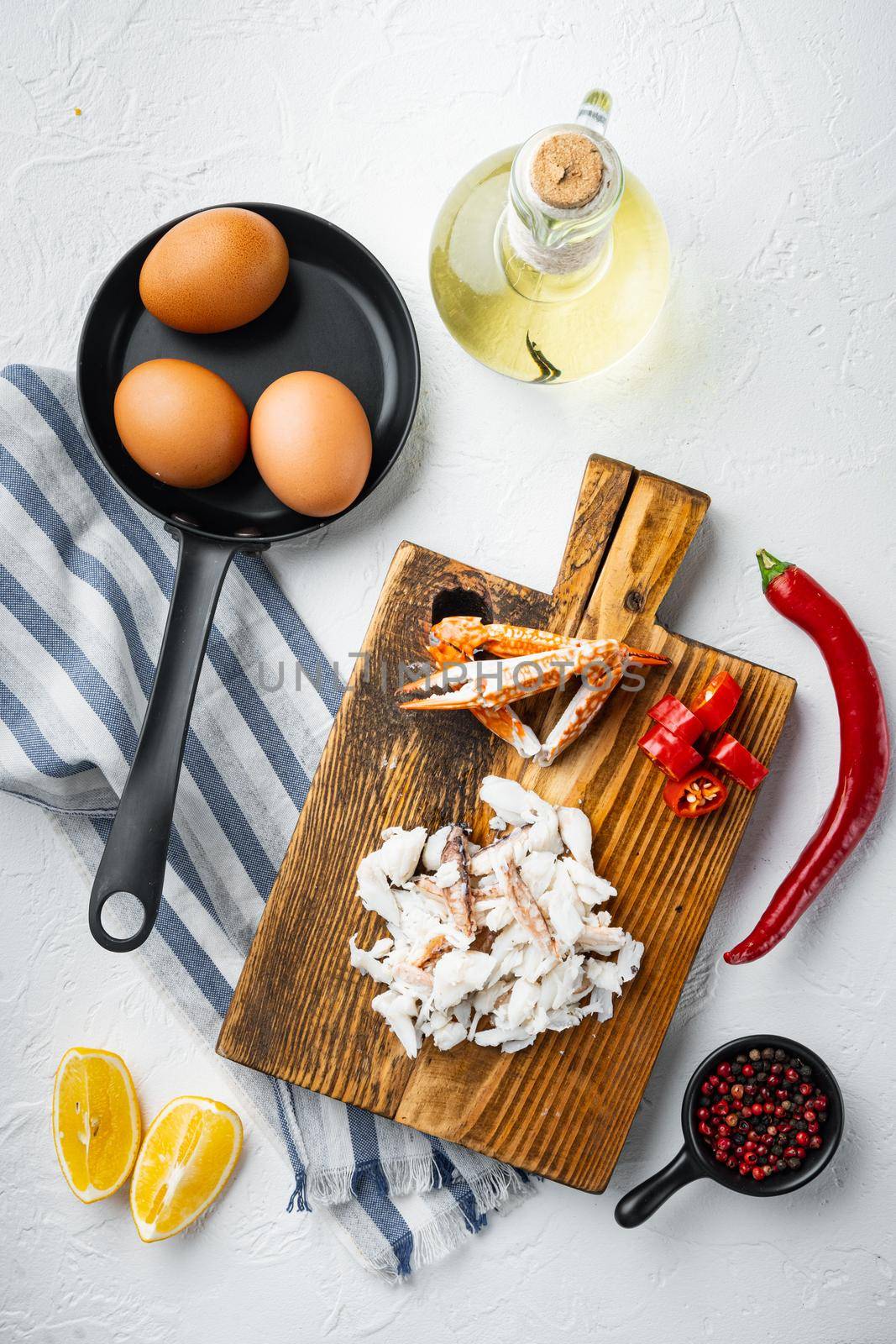 Spanish or Thai omelette ingredient, fresh red chilli, brown and white crabmeat, lemon, Cheddar cheese, eggs set, on white background, top view flat lay