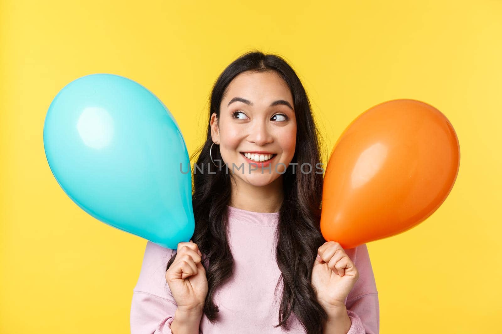 People emotions, lifestyle leisure and beauty concept. Beautiful dreamy asian girl with two balloons looking excited and intrigued at upper left corner, smiling cheerful, imagine lots of gifts by Benzoix