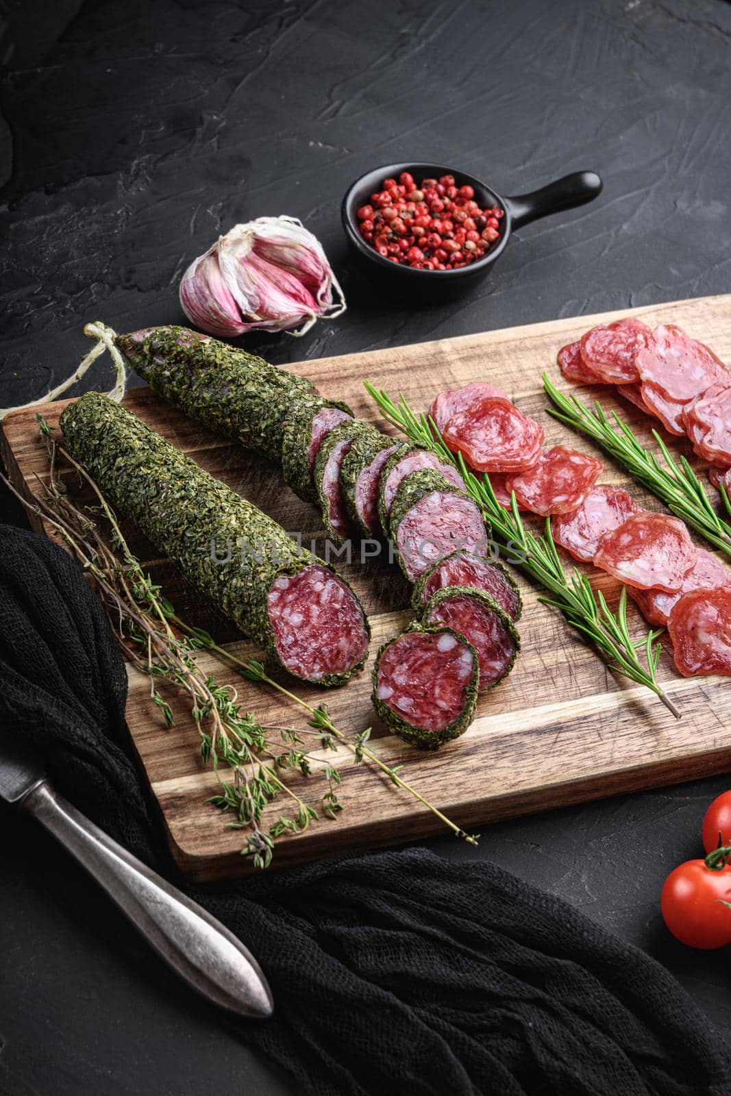 Spanish fuet salami sausage slices on balck background.