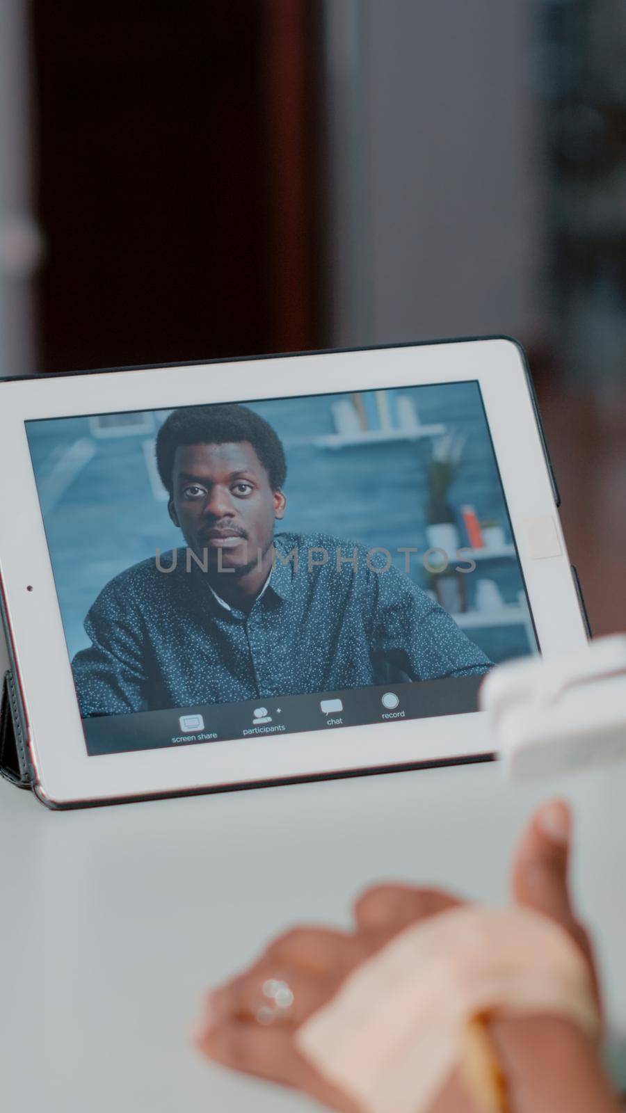 Close up of patient using video call on digital tablet to talk to man while laying in hospital ward bed. Person talking to friend on online video conference on device. Remote communication