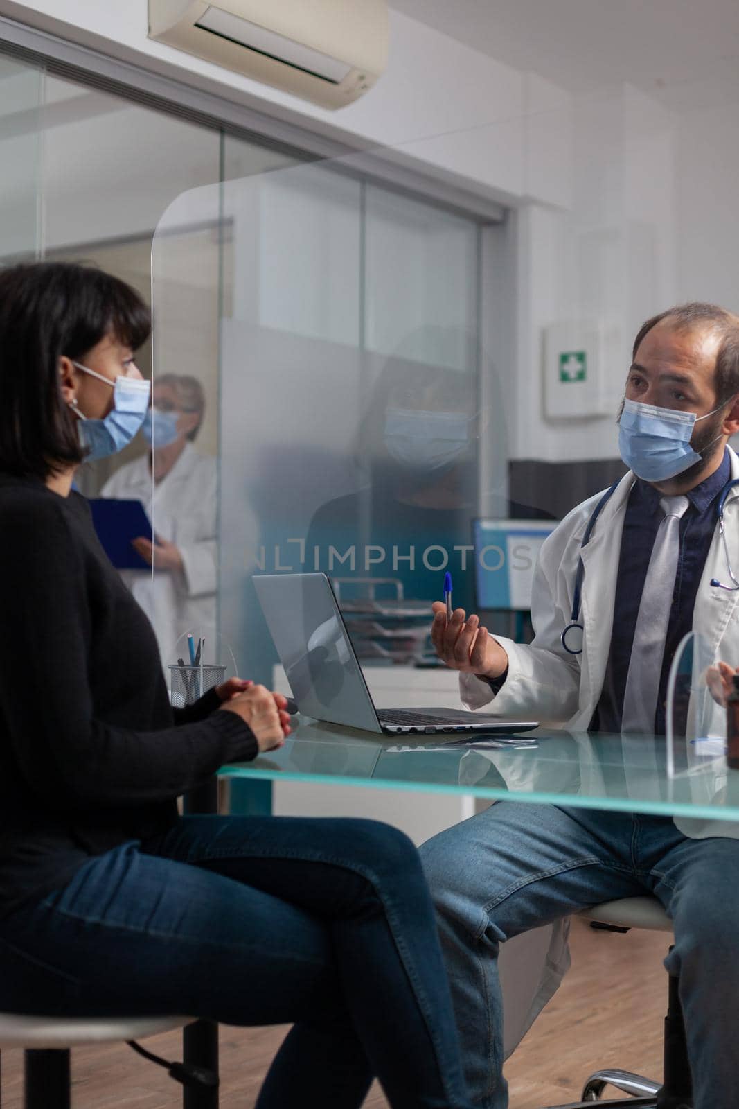 Doctor and patient discussing about health care at appointment by DCStudio