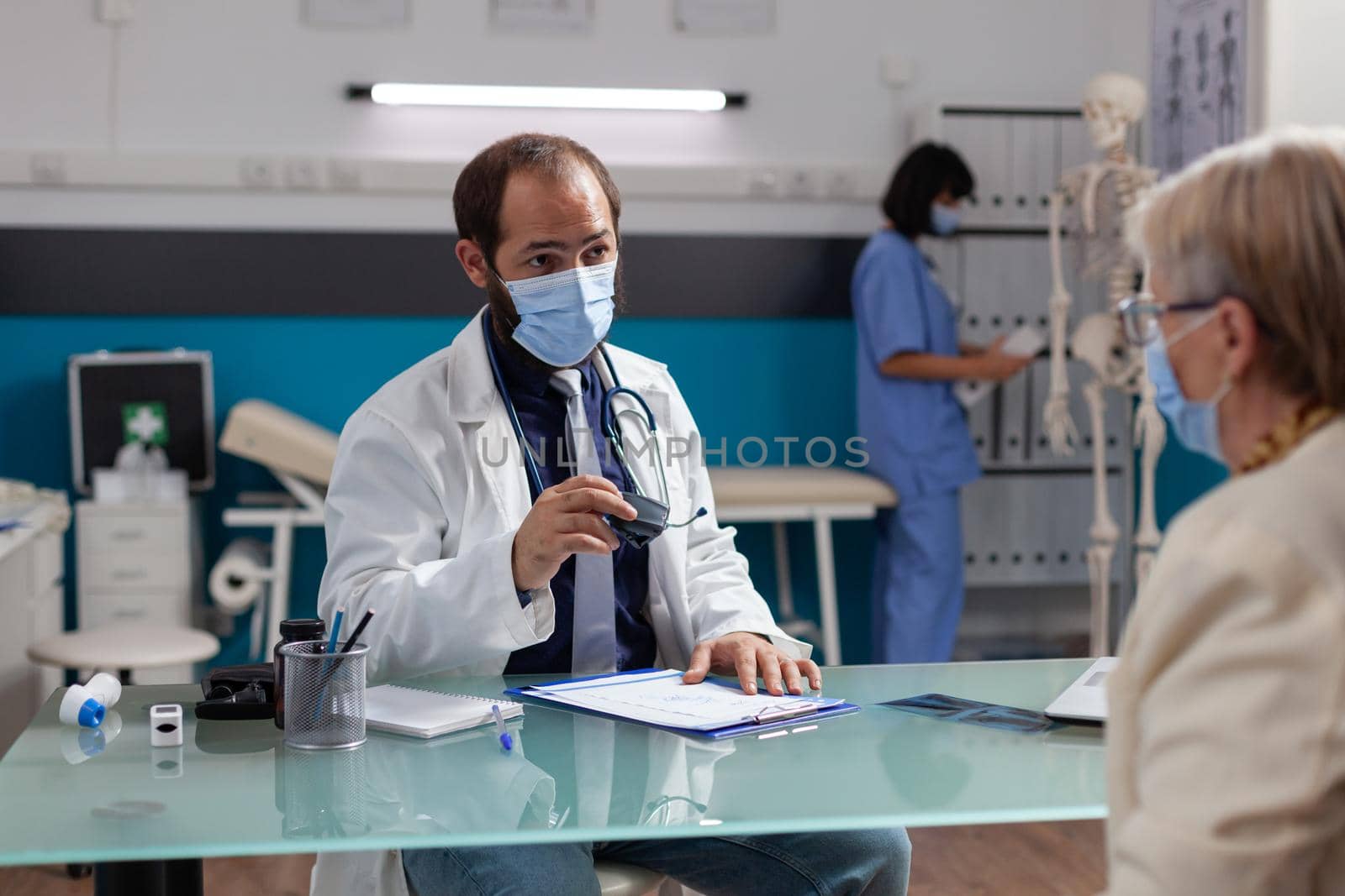 Medic with face mask using medical seal on prescription document by DCStudio