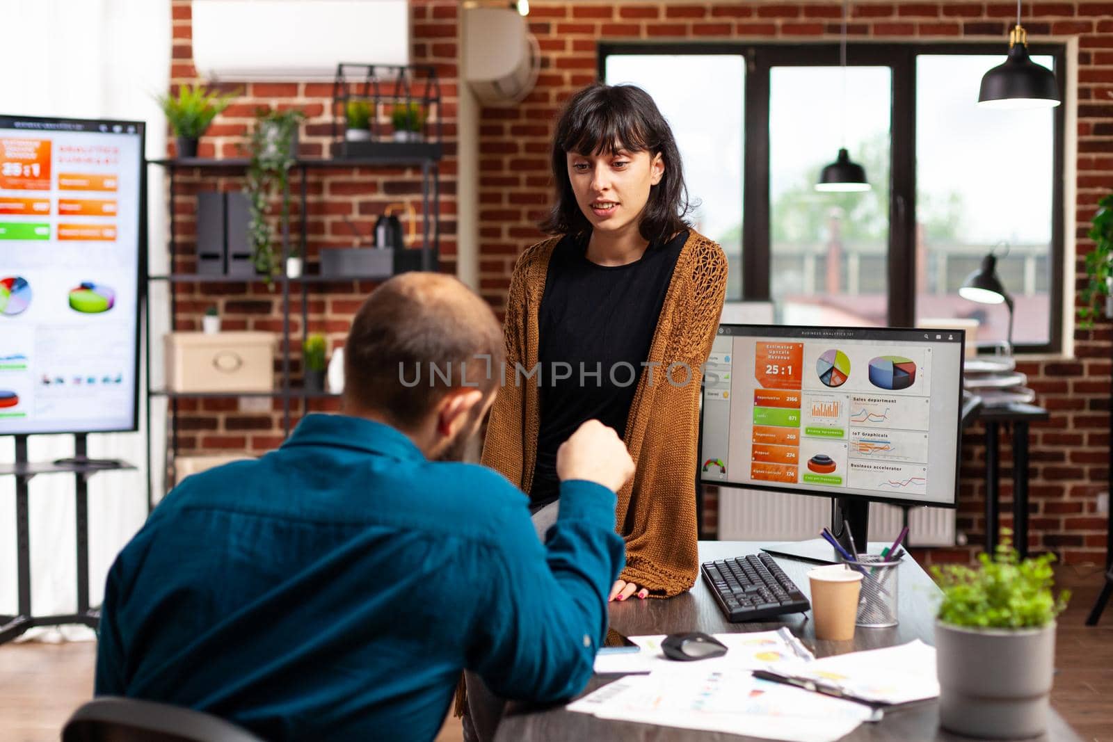 Executive manager explaining business strategy to woman entrepreneur showing company data chart by DCStudio