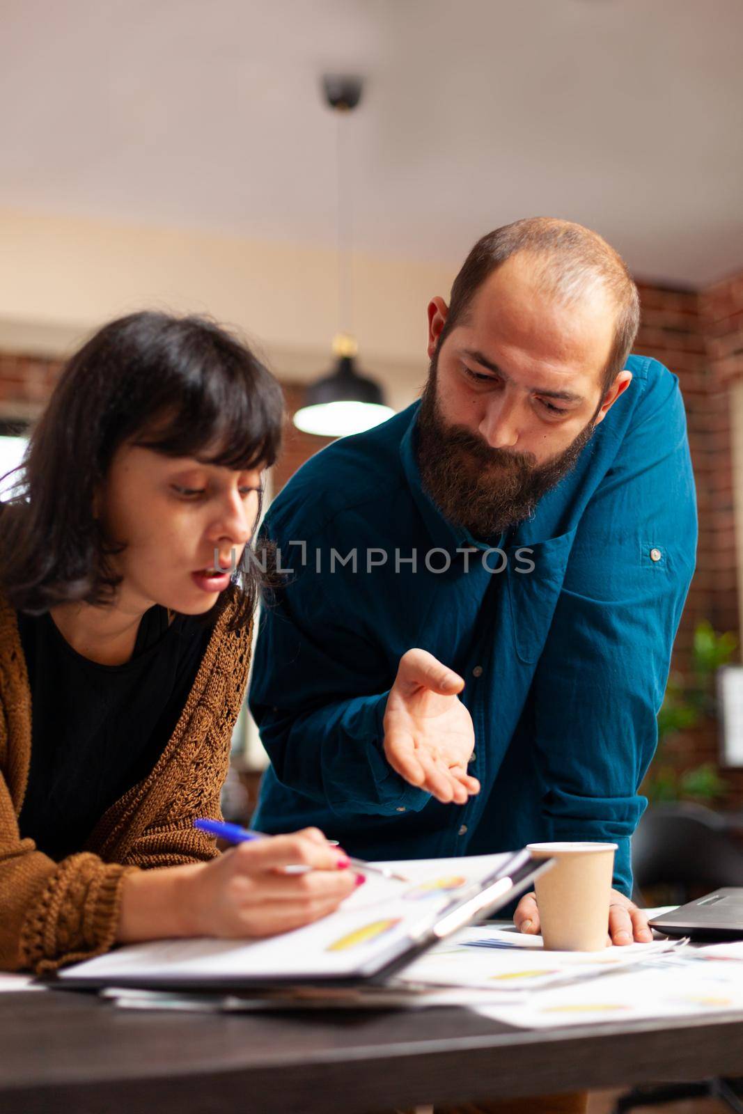 Businessman explaining company strategy to entrepreneur working at marketing project by DCStudio