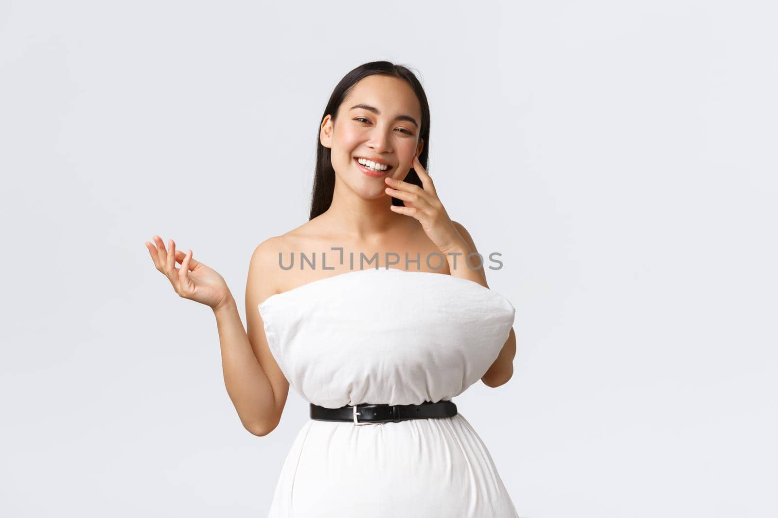 Beauty, fashion and social media concept. Pretty happy asian woman laughing and show-off her new outfit made of pillow and belt, posing in pillow dress over white background.