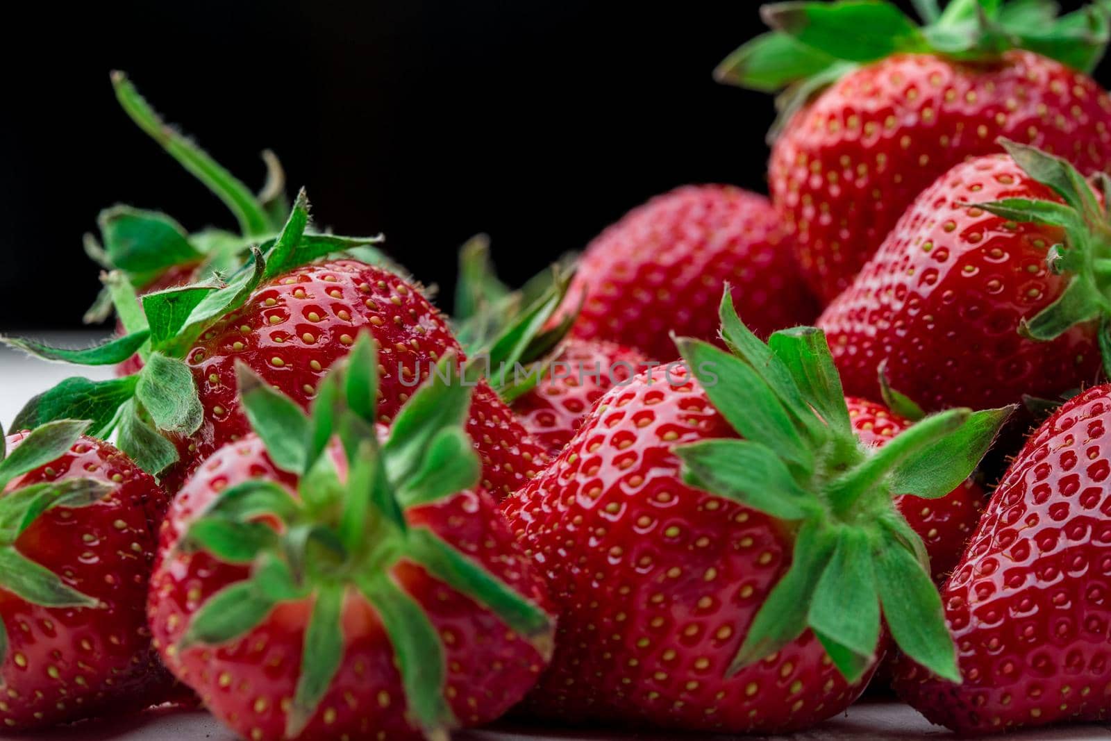 Red Strawberry, red close up strawberries with selective focus on a strawberry with many strawberries in the background for food or fruit close up background or strawberry texture.