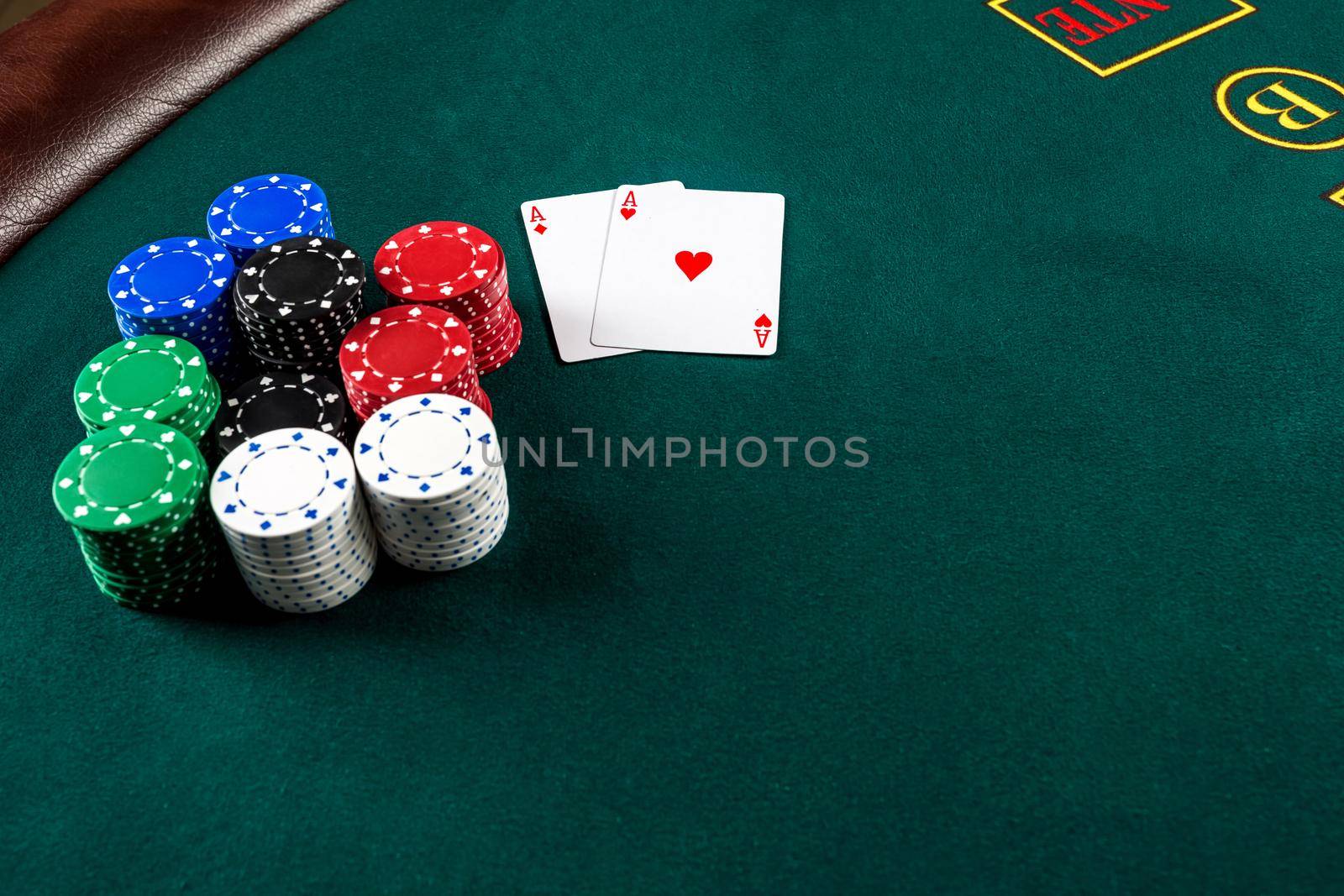 Poker play. Chips and cards on the green table