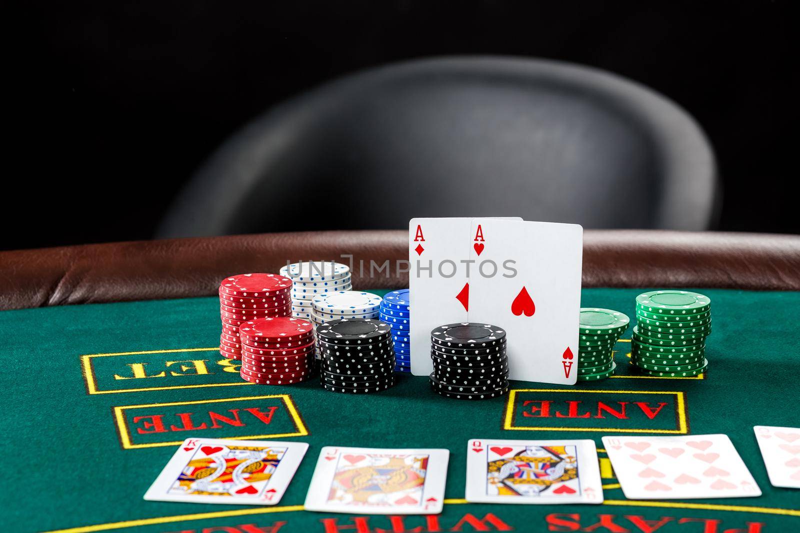 Poker play. Chips and cards on the green table