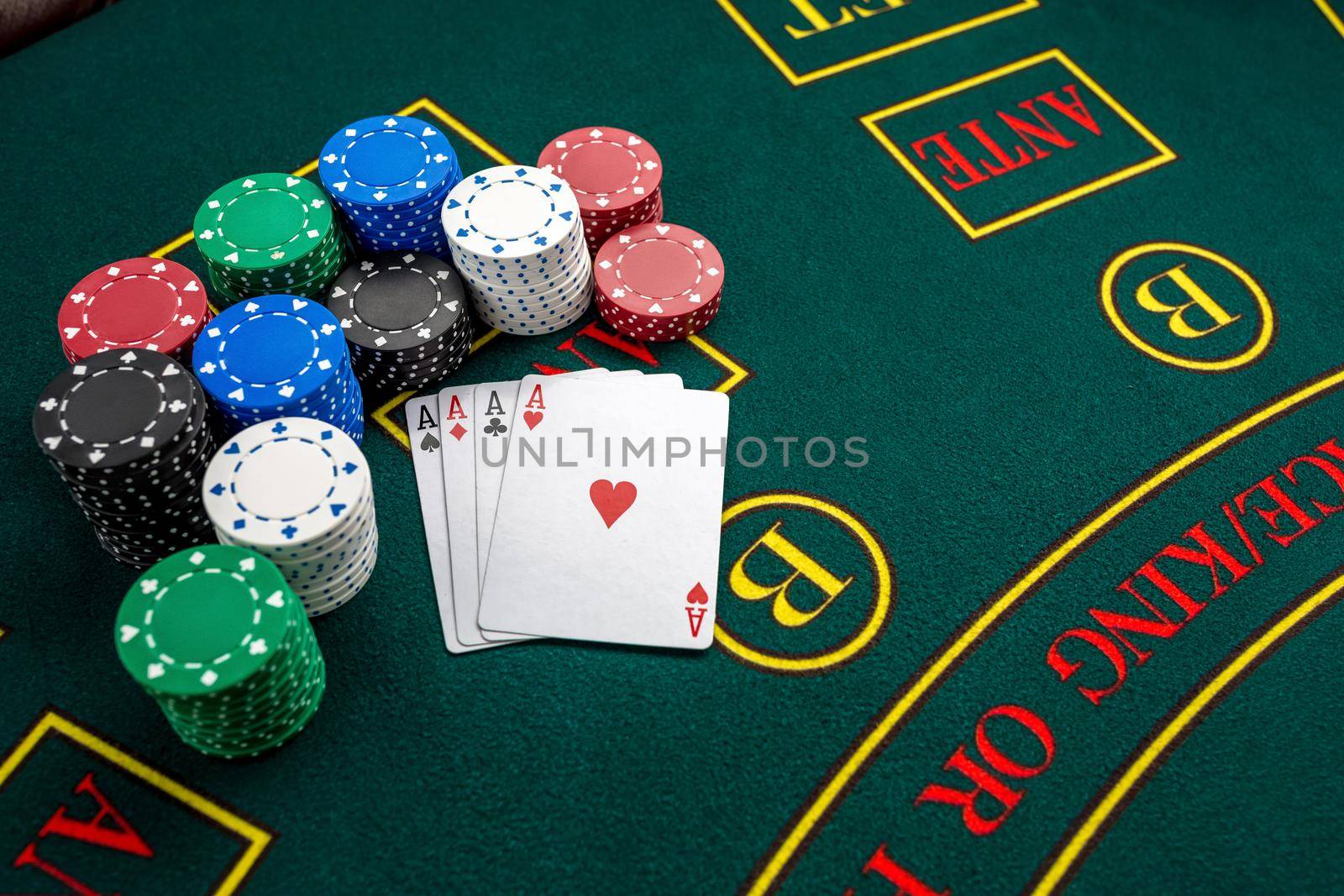 Poker play. Chips and cards on the green table