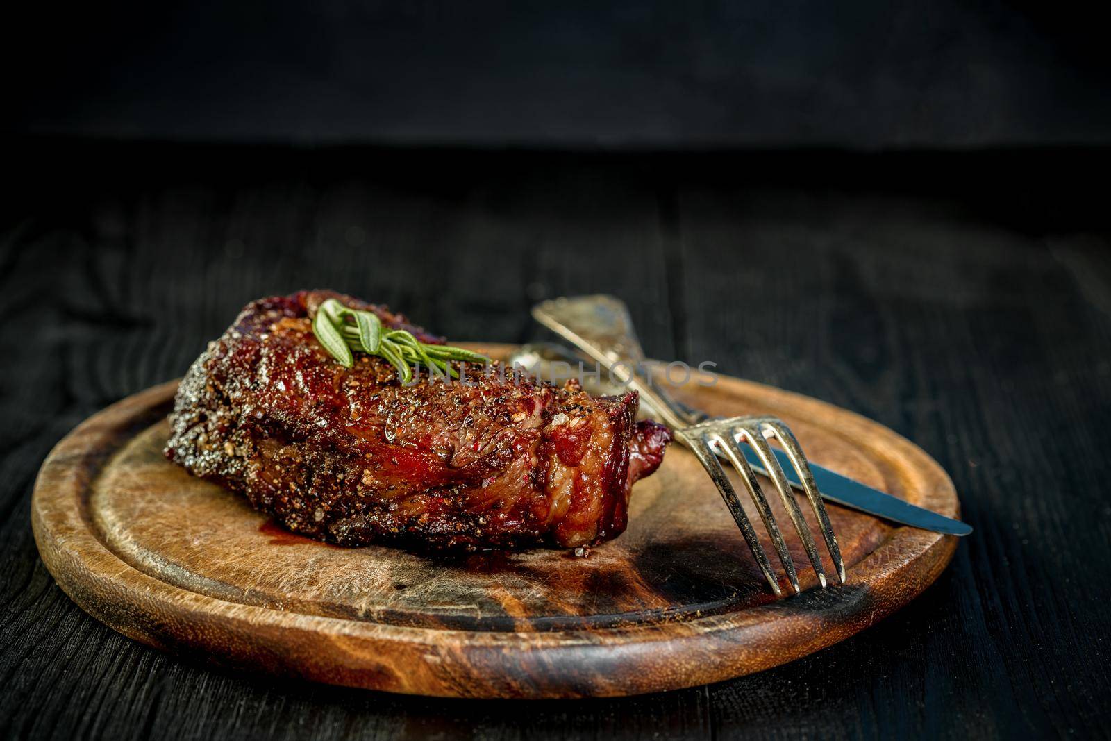 Barbecue Dry aged Ribeye Steak with knife and fork on cutting board by nazarovsergey