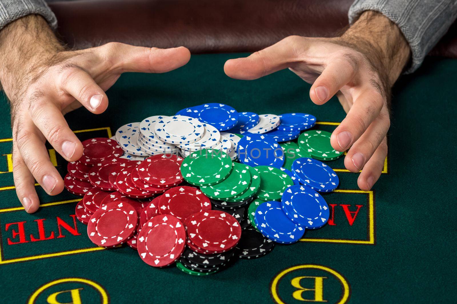 Poker play. Chips on the green table. chips in male hands