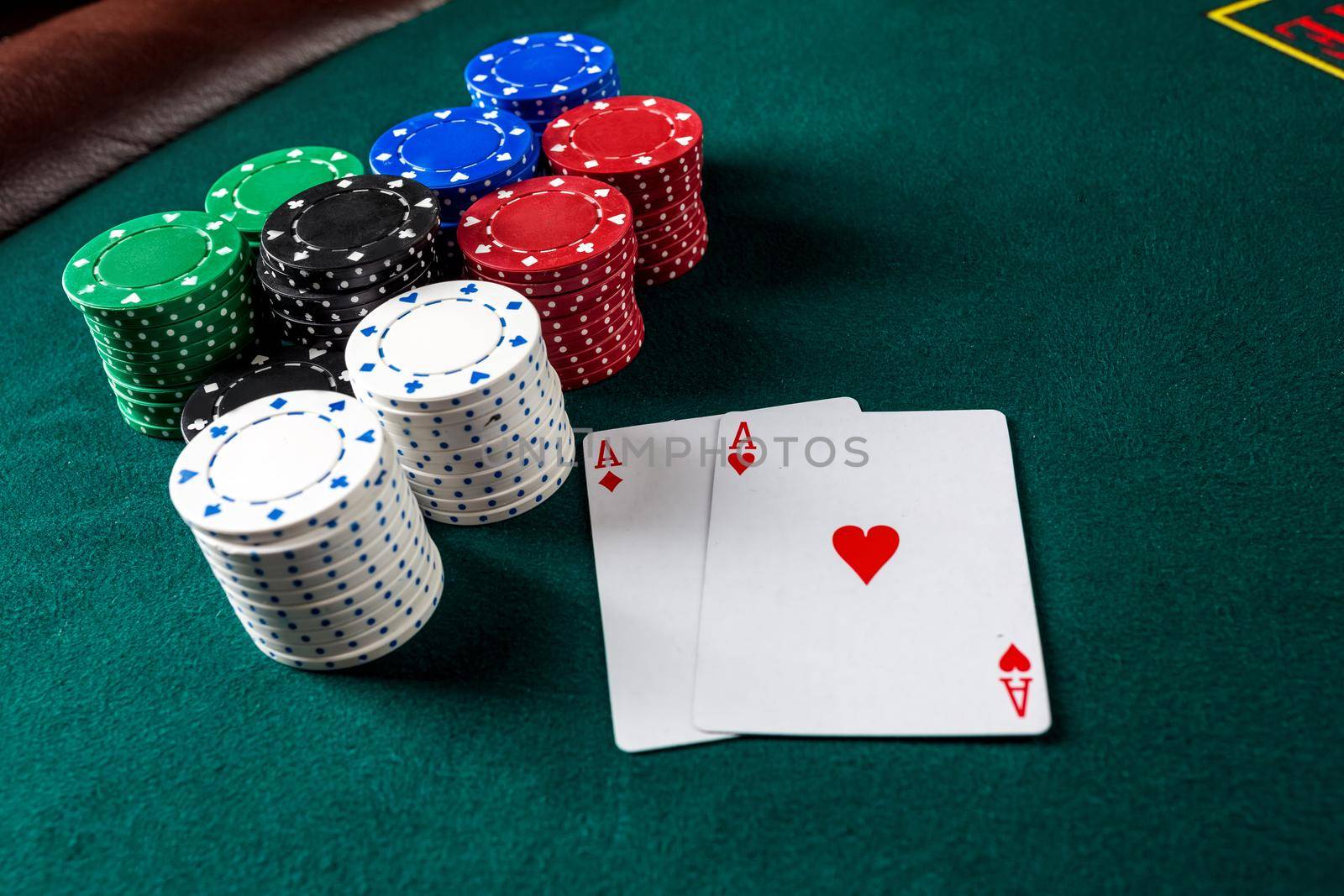 Poker play. Chips and cards on the green table