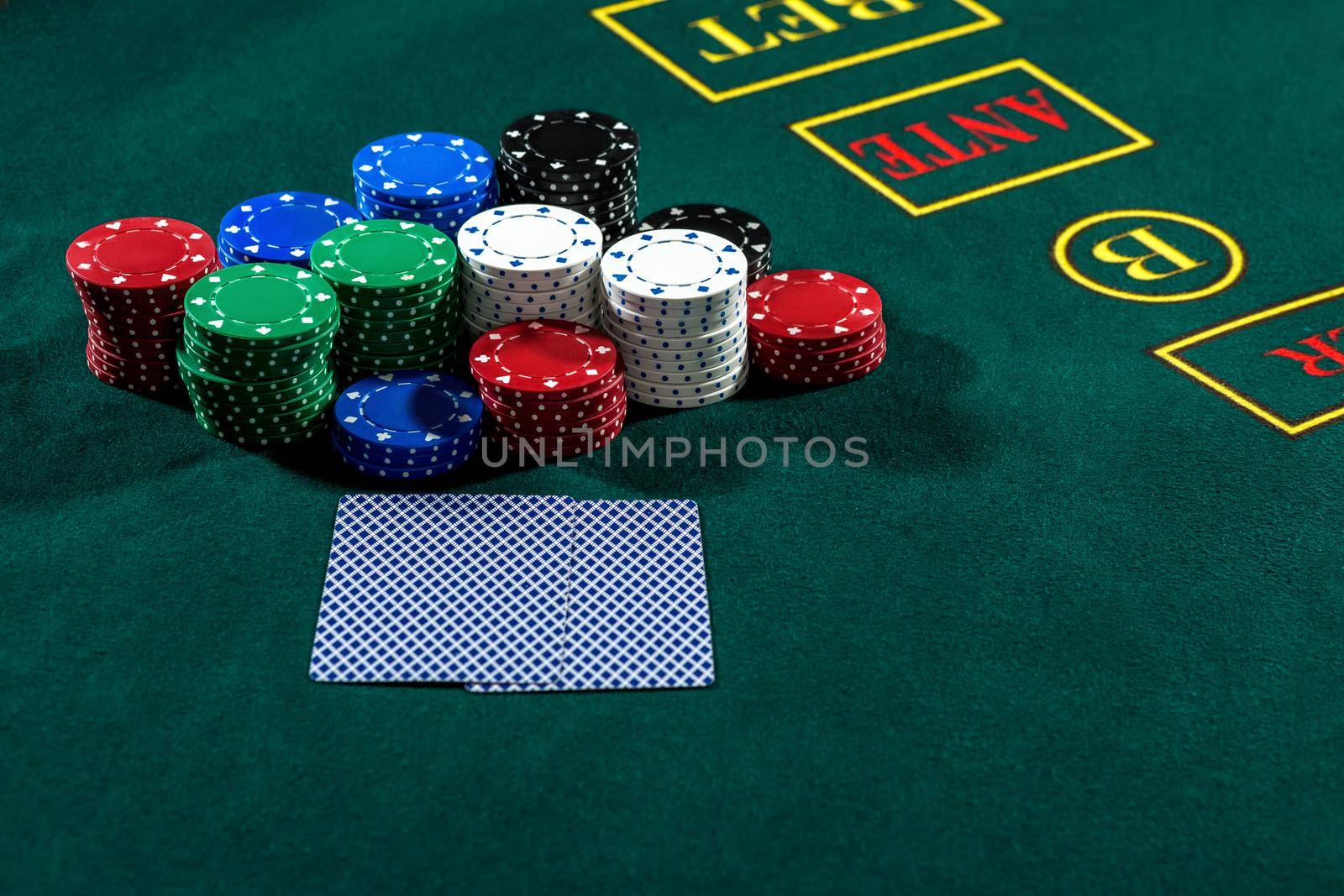 Poker play. Chips and cards on the green table